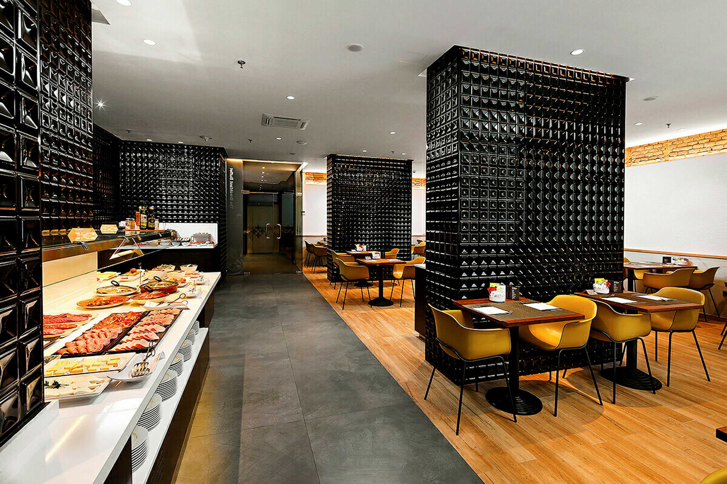 Restaurant med svartmønstrede vegger, en frokostbuffet og spiseområder med moderne møbler. (AI-generert tekst)