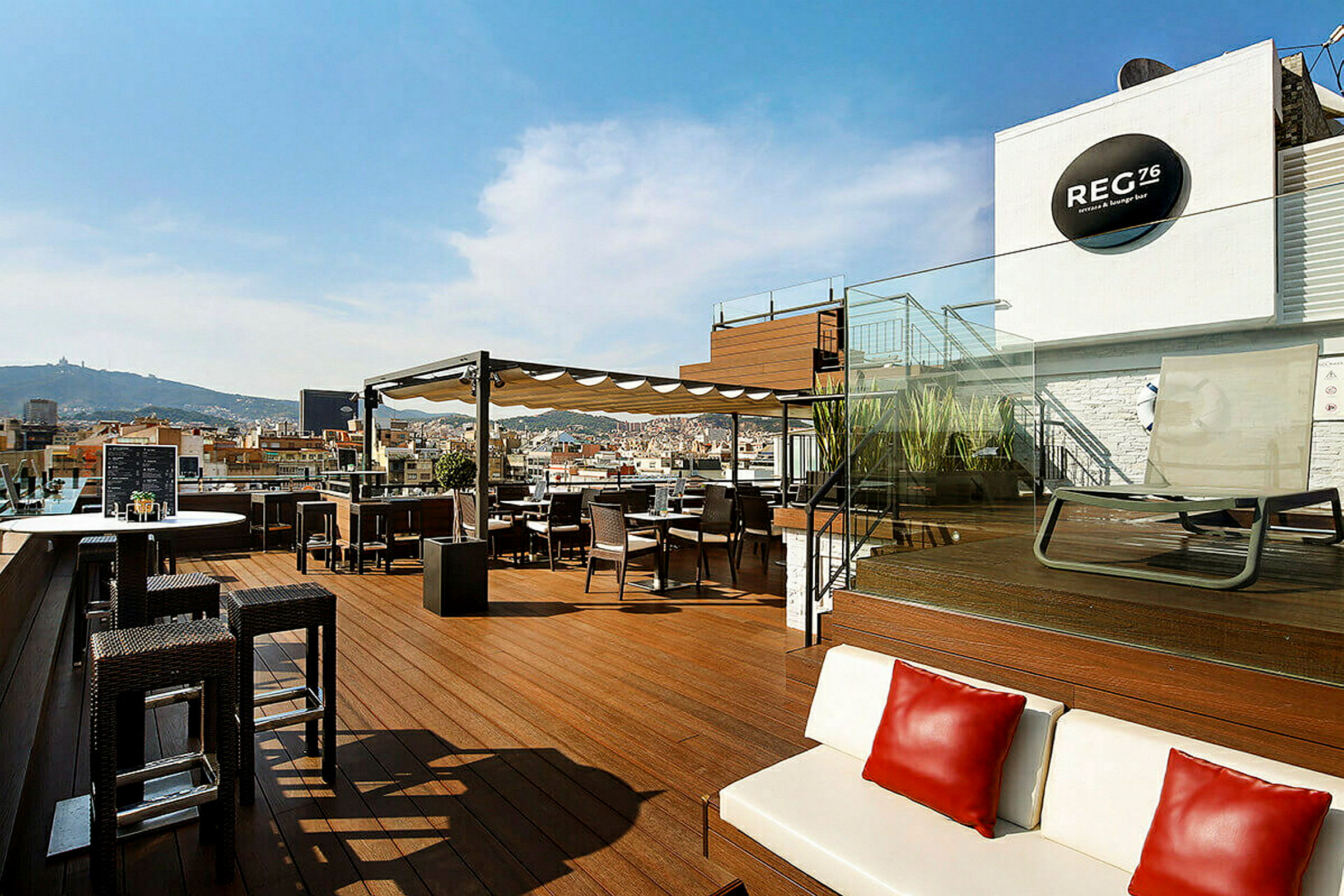 En takterrasse med sitteplasser, bord og en loungeområde med utsikt over byen. (AI-generert tekst)