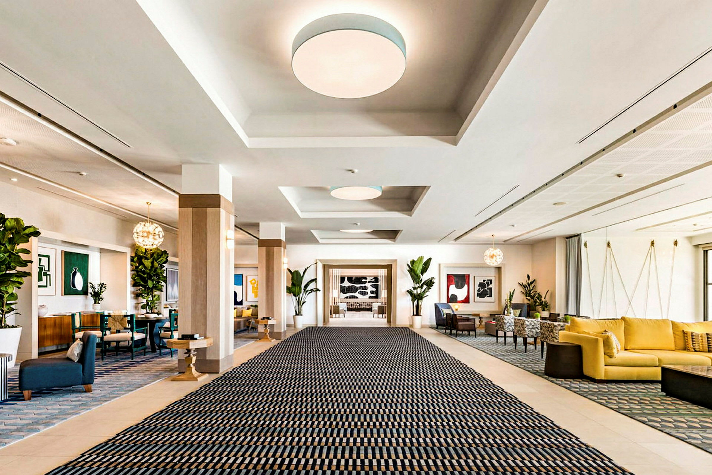 En romslig hotellobby med et stort teppe, sittegrupper og dekorasjoner. (AI-generert tekst)