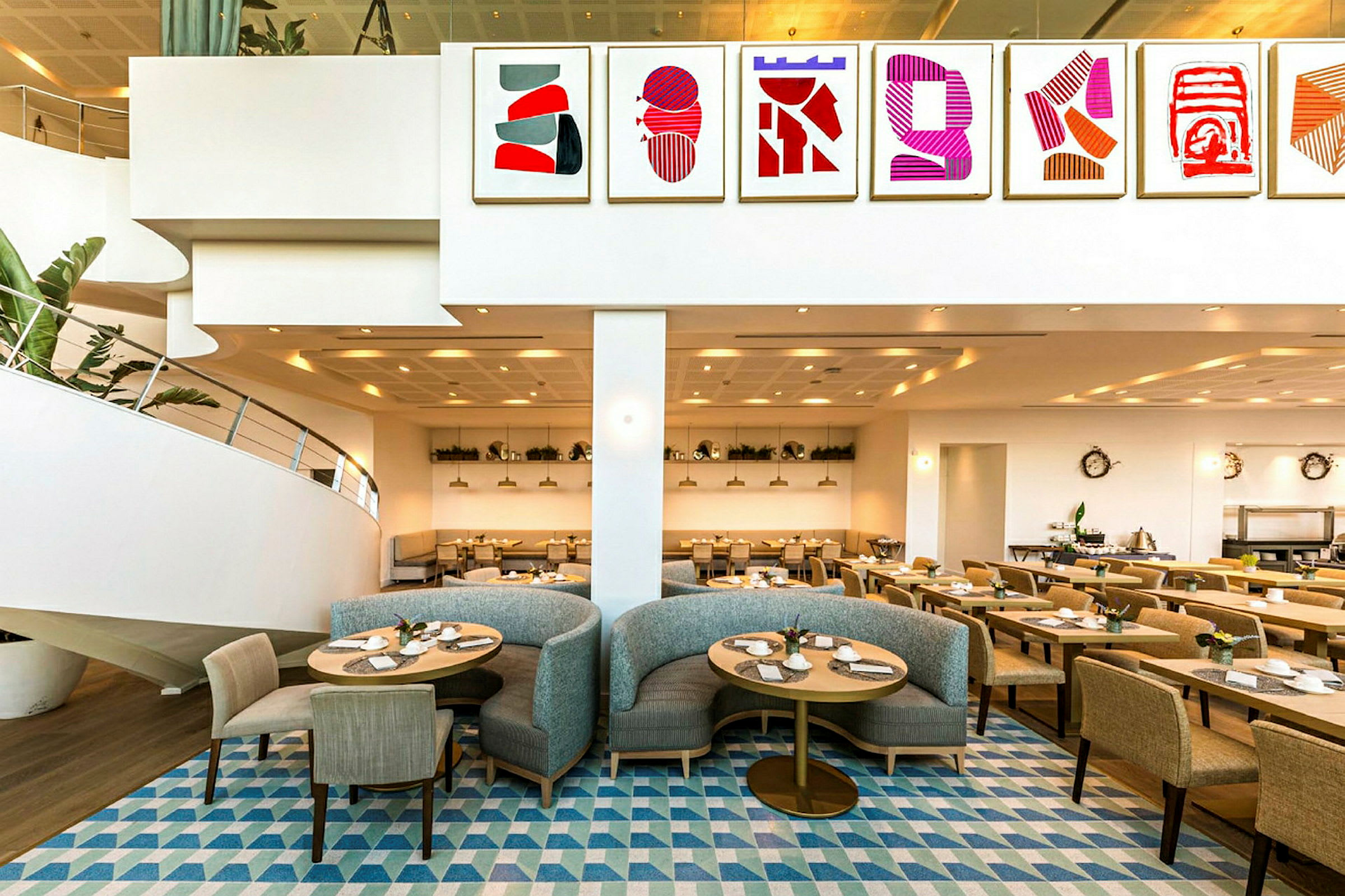 En restaurant med moderne interiør, malerier på veggen og sitteplasser med stoler og sofaer. (AI-generert tekst)