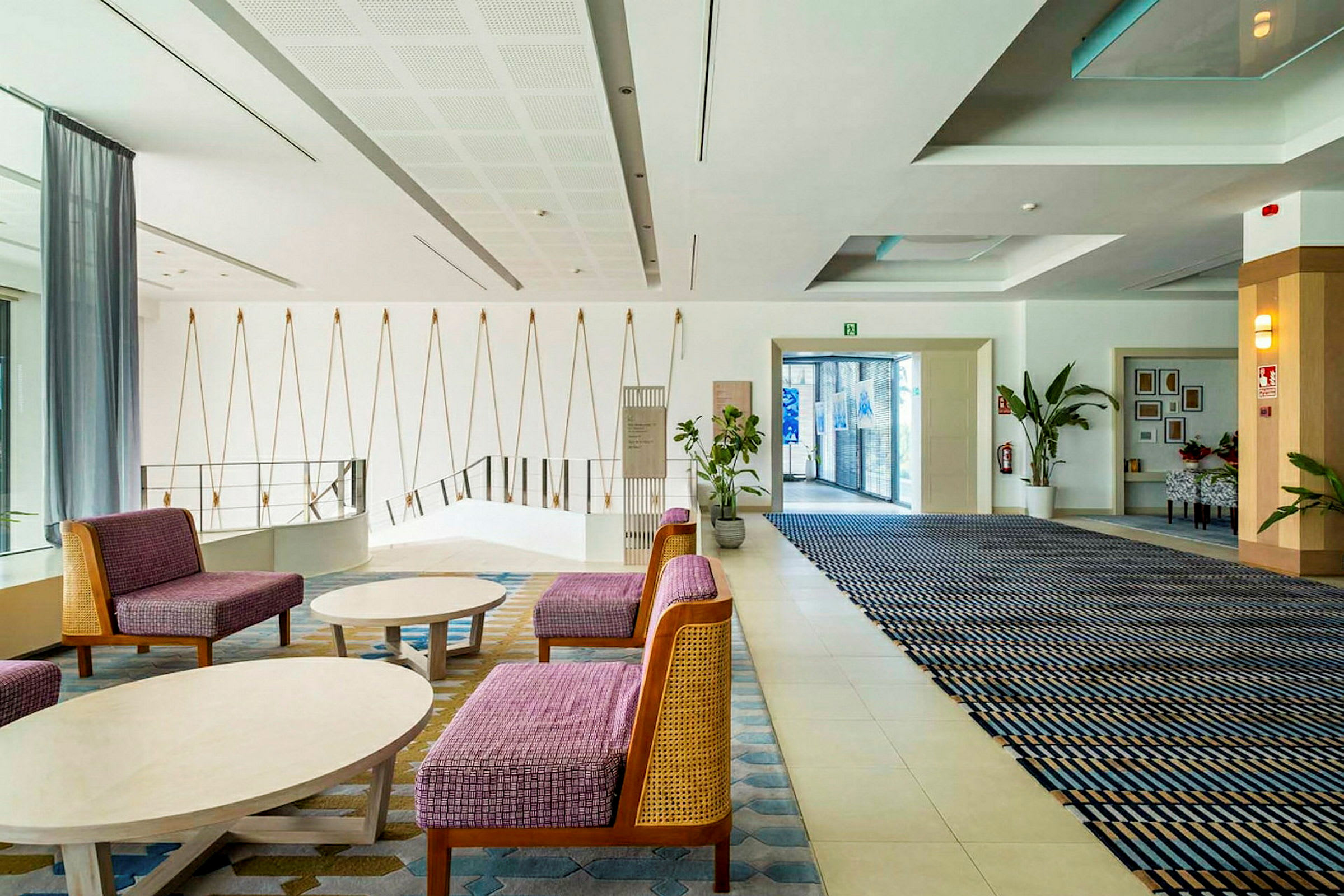 Et moderne hotellobbyområde med sittemøbler, veggdekorasjoner og plantearrangementer. (AI-generert tekst)