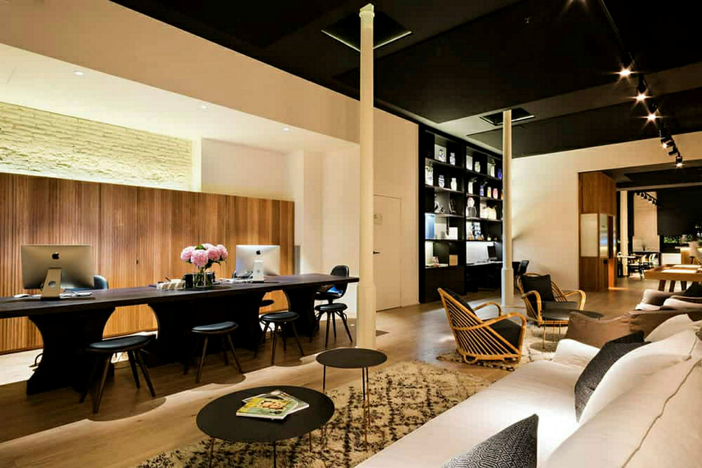 Moderne innredet lounge med skrivebord, datamaskiner og sofaer. (AI-generert tekst)