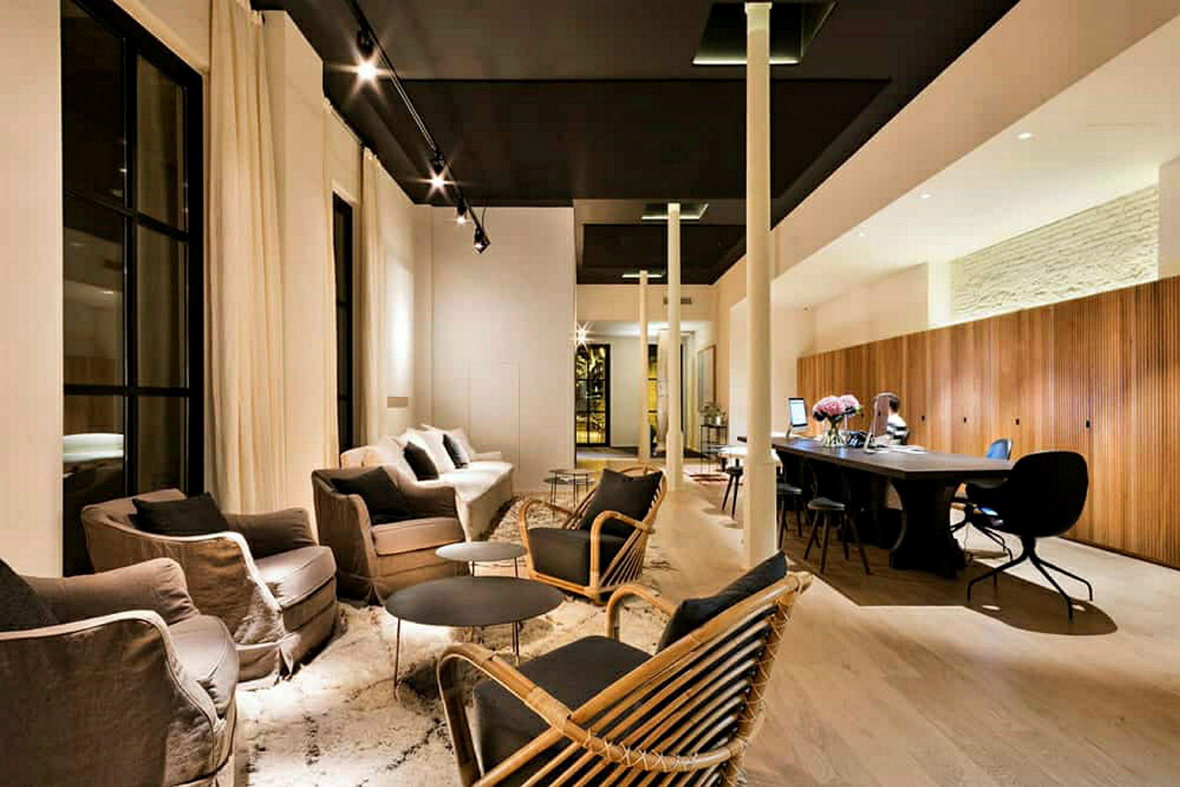 En moderne innredet lounge med sofaer, lenestoler, bord og arbeidsområde. (AI-generert tekst)