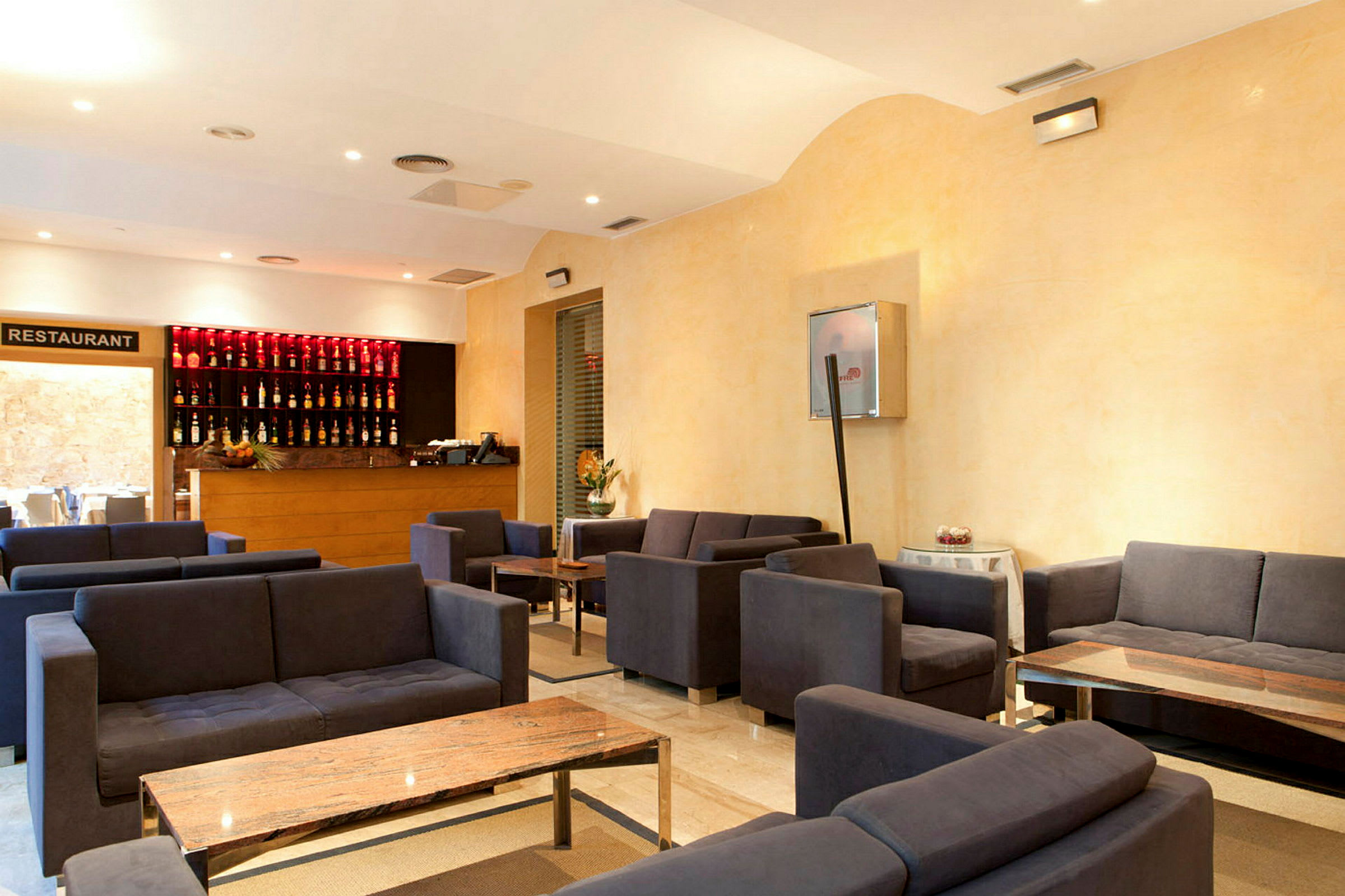 En hotellobby med flere sittegrupper og et resepsjonsområde. (AI-generert tekst)