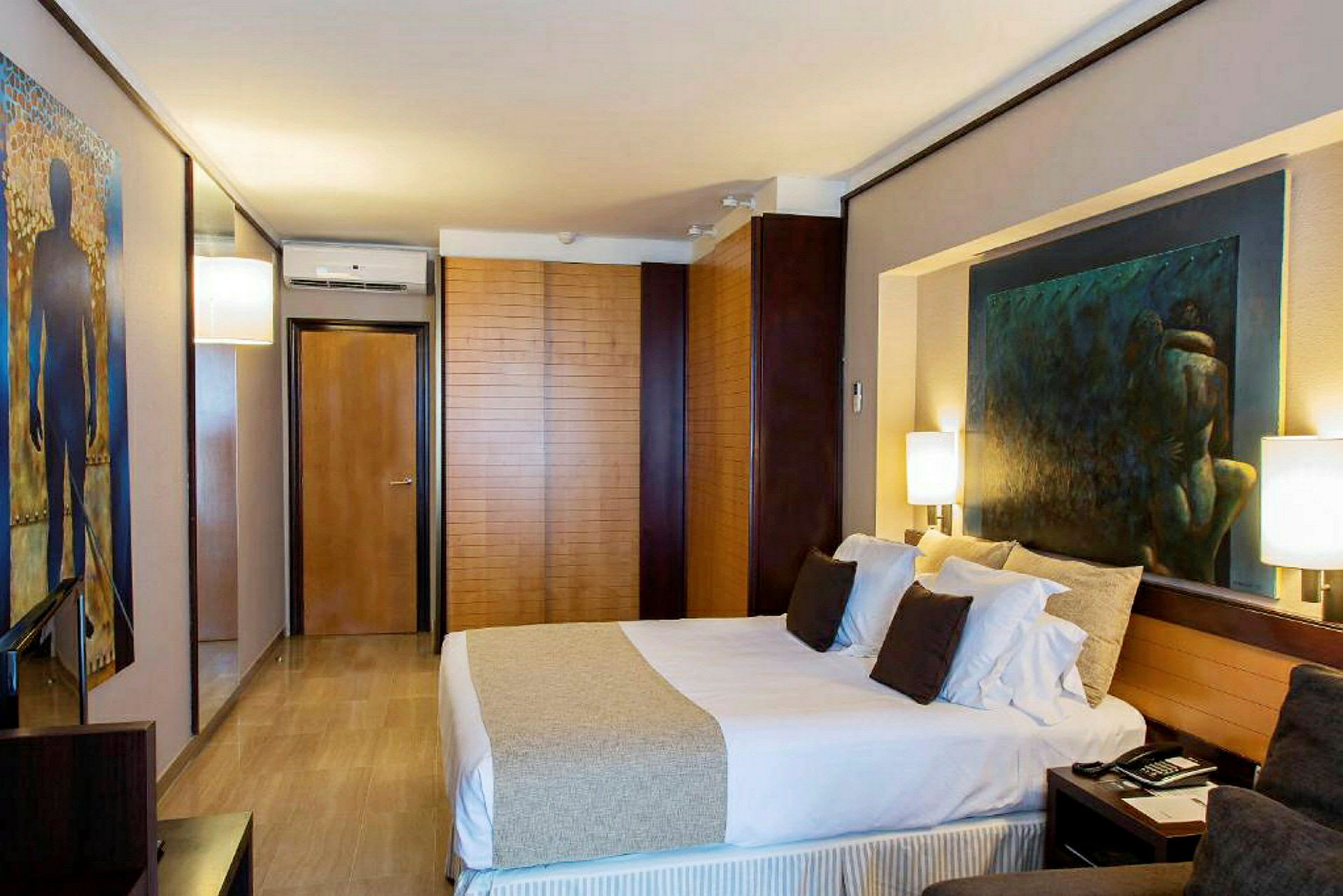 Et moderne hotellrom med en dobbeltseng, kunst på veggene og elegant interiør. (AI-generert tekst)