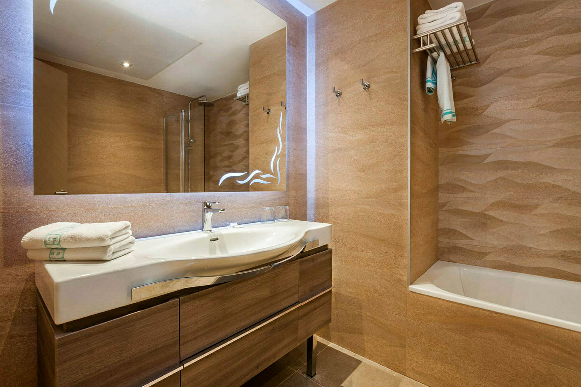 Hotellbad med servant, speil, badekar og håndklær. (AI-generert tekst)