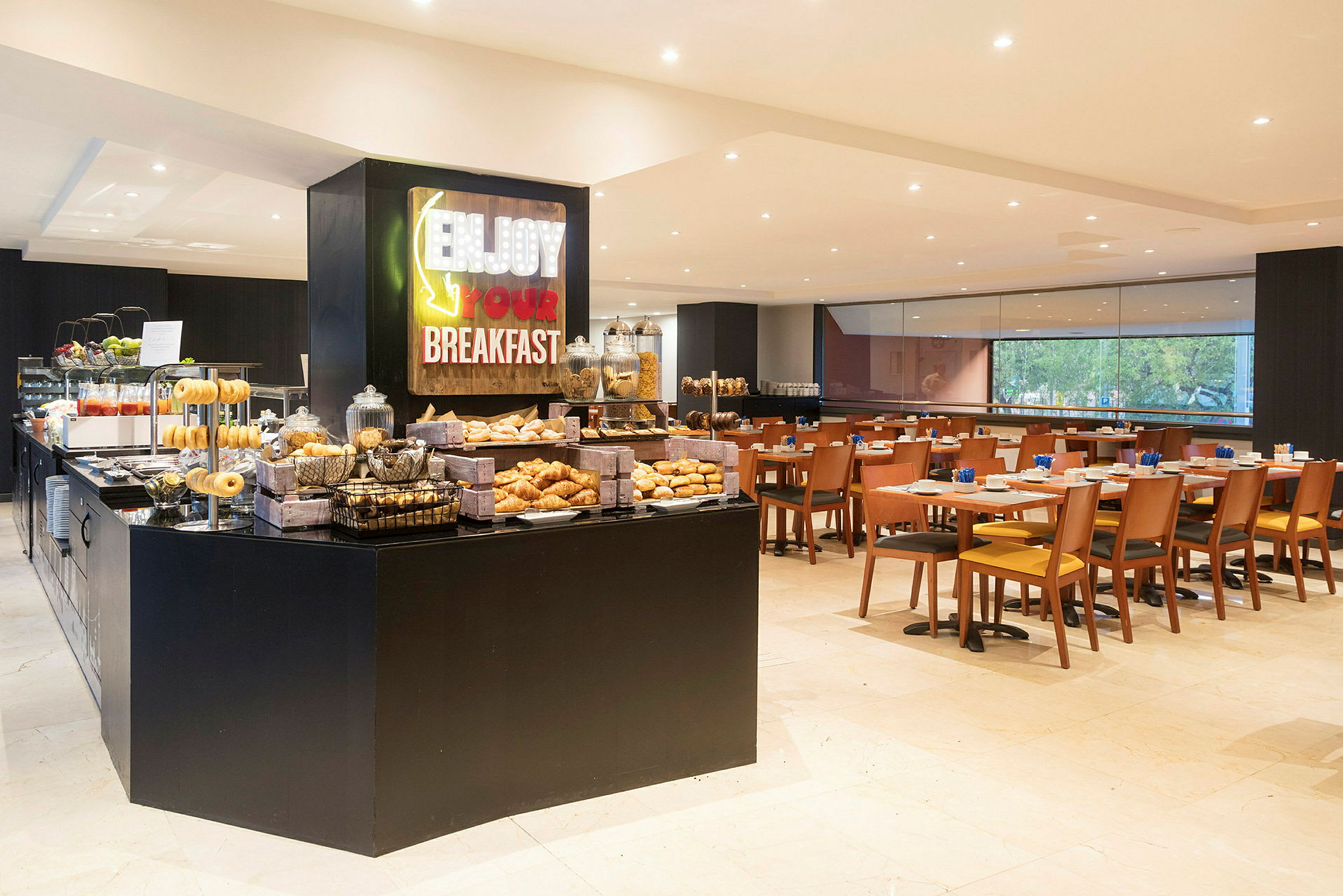 Bilde av en frokostbuffet og spiseområde. Buffeten tilbyr et utvalg av bakverk og drikke. (AI-generert tekst)