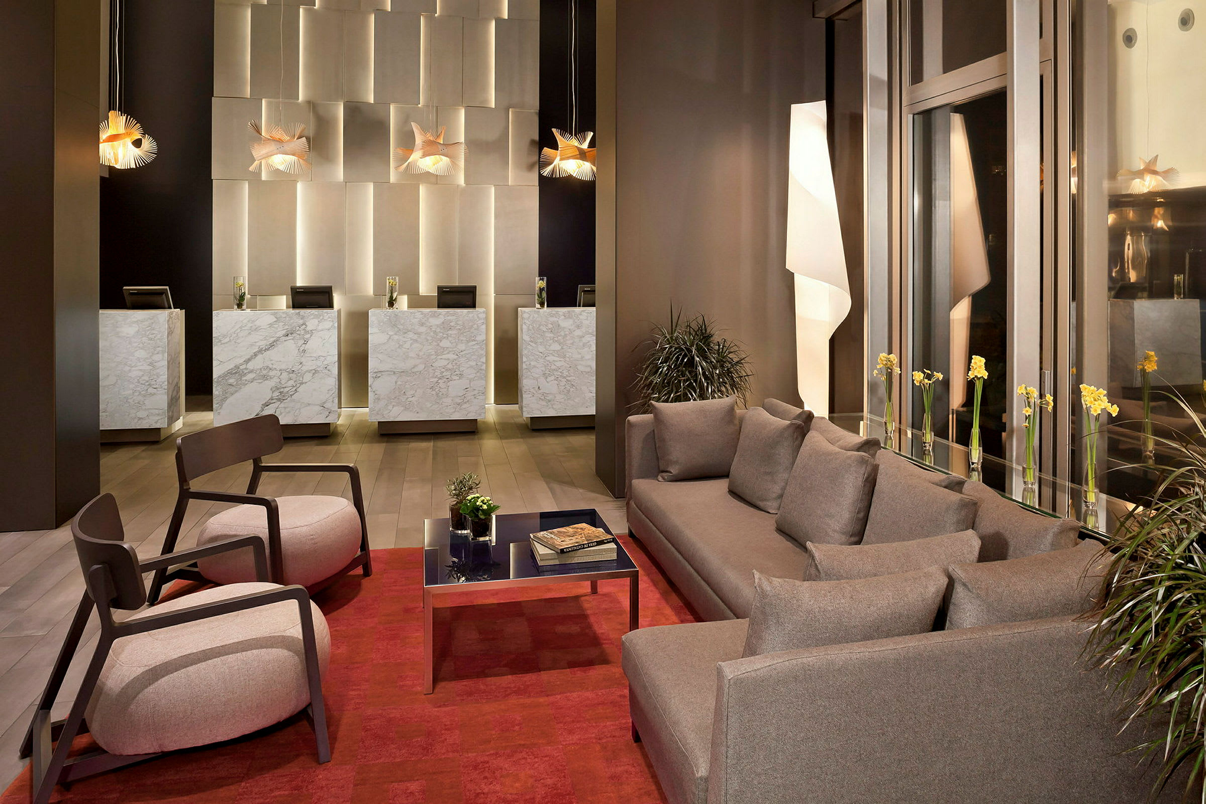 Bilde av en hotellobby med marmordisker, moderne sofaer og lenestoler samt dekorative lamper. (AI-generert tekst)