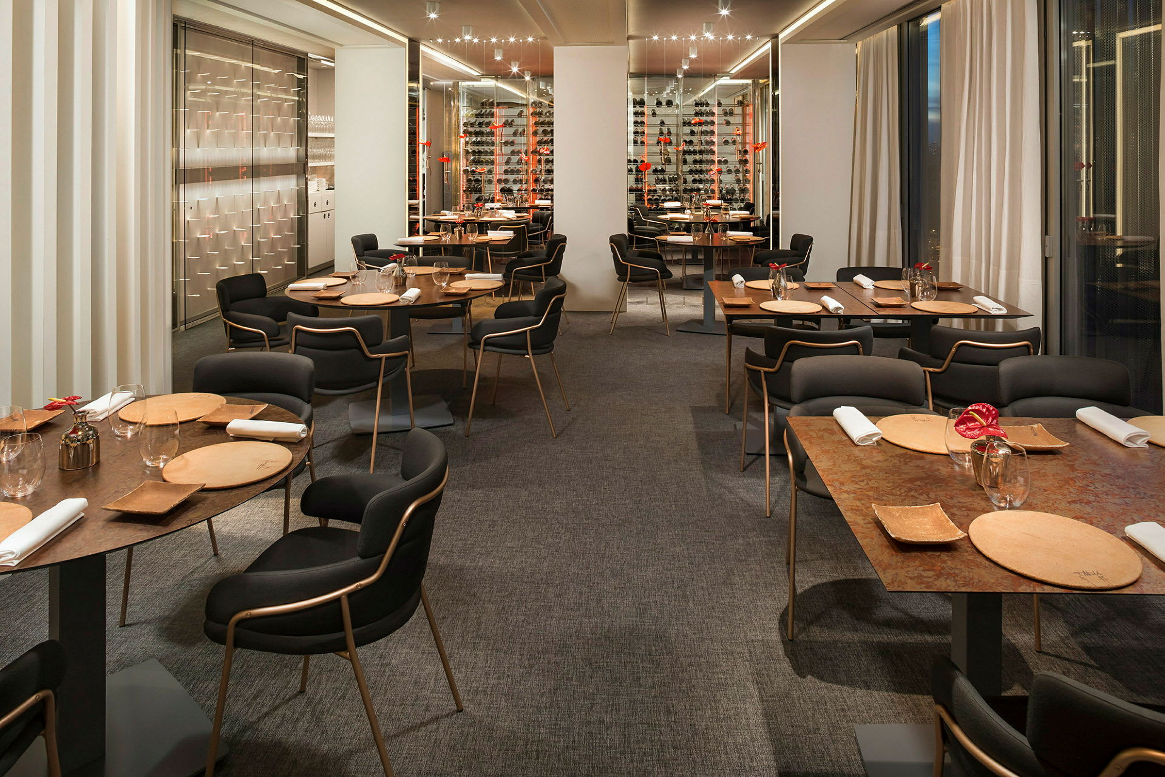 En restaurant med moderne interiør, bord dekket med tallerkener, glass og servietter. (AI-generert tekst)