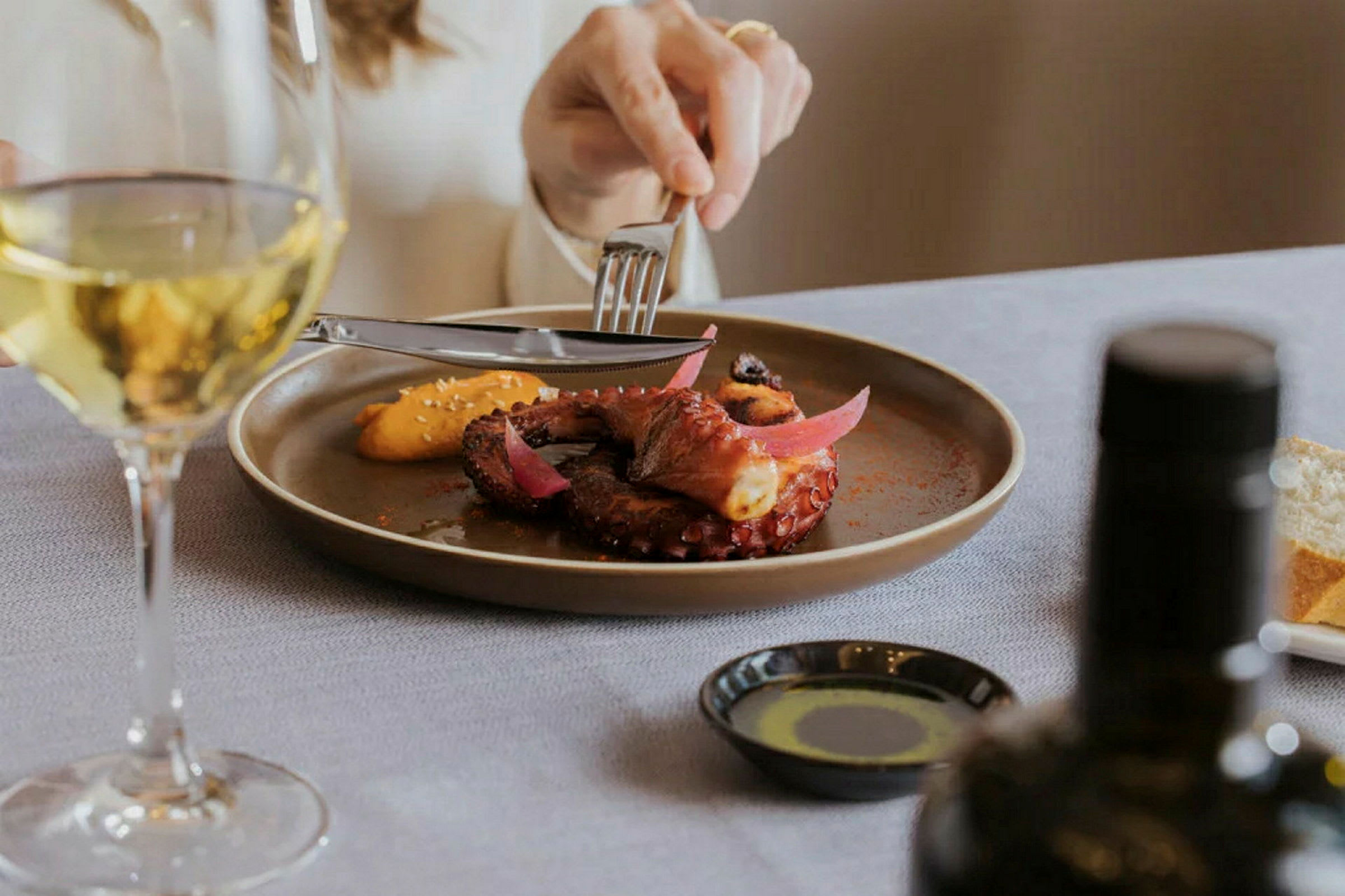 Et elegant anrett måltid med tilhørende glass hvitvin. (AI-generert tekst)