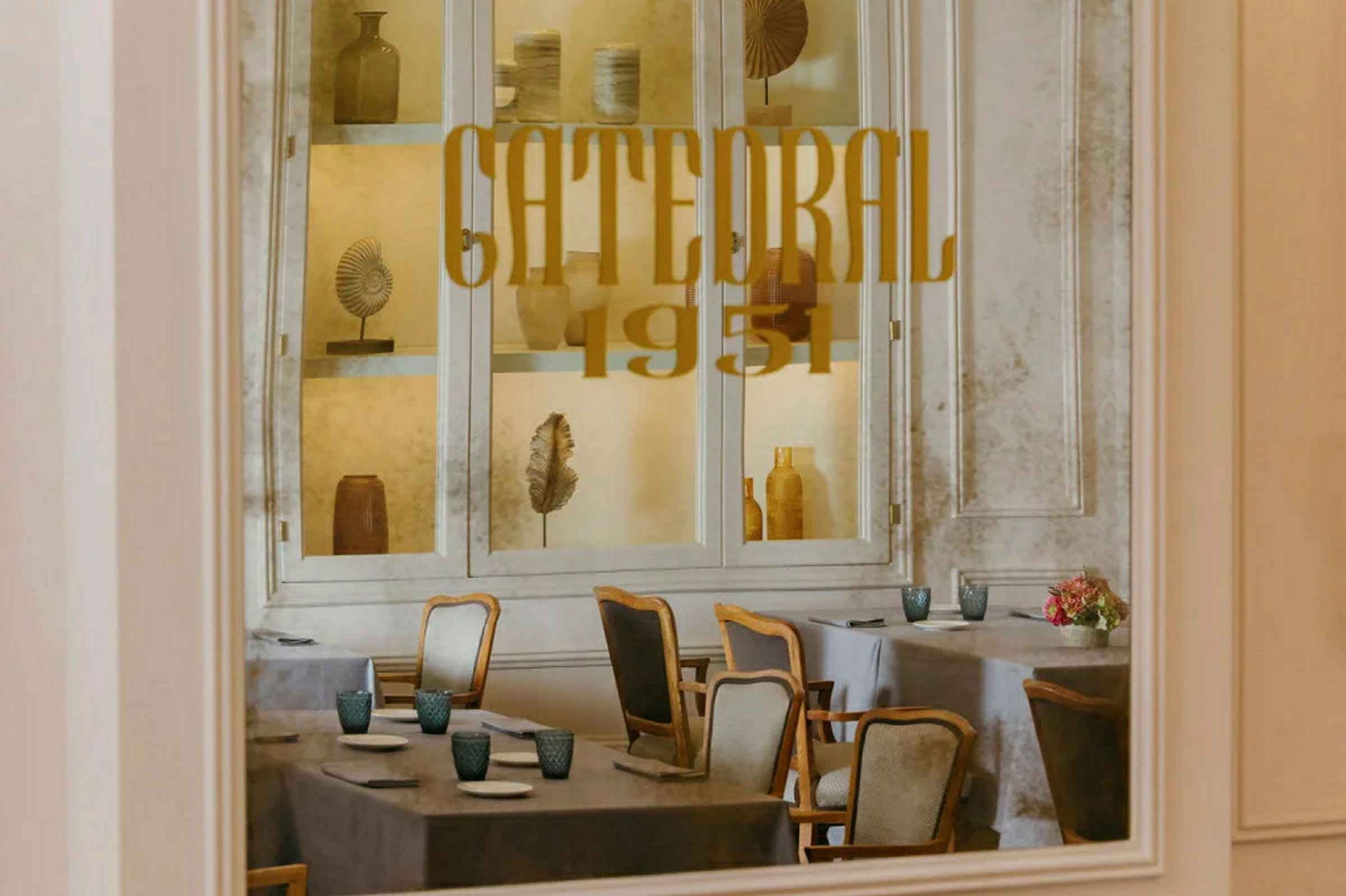 Interiøret til en restaurant med borddekking og dekorasjoner bak glass. (AI-generert tekst)