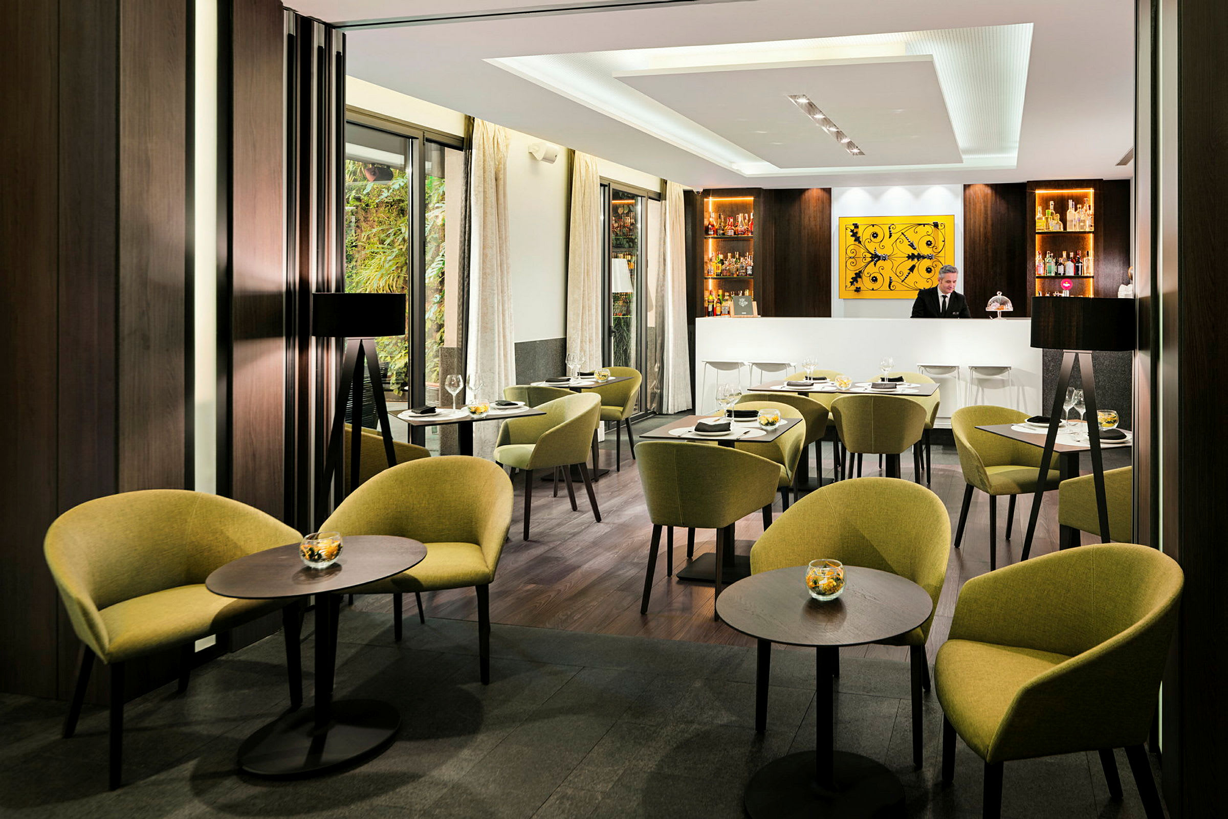 En elegant restaurant med bord, stoler og en bar i bakgrunnen. (AI-generert tekst)