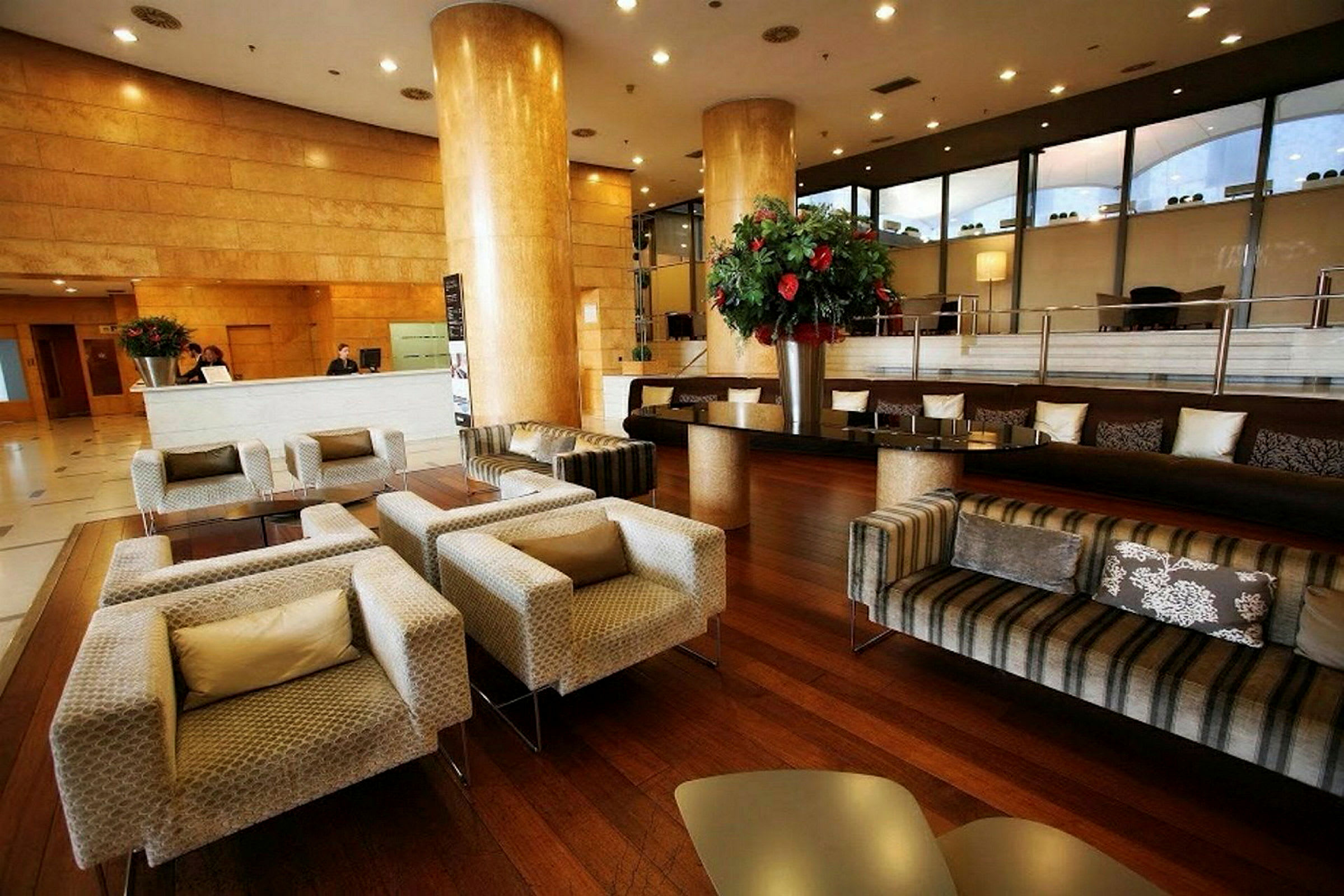 En elegant hotellobby med sittegrupper og moderne møbler. (AI-generert tekst)