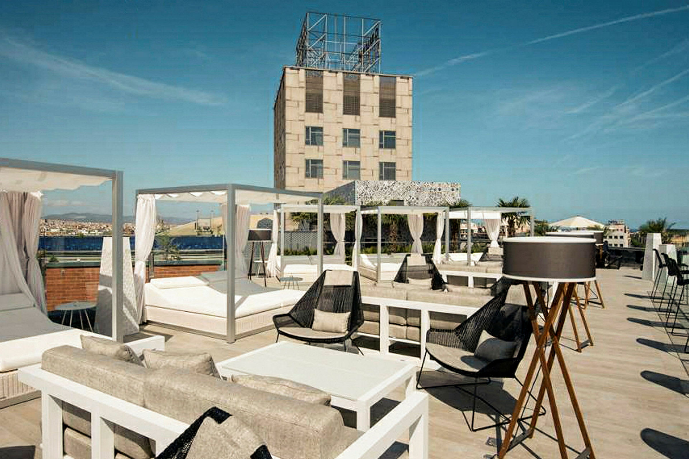 En takterrasse med sittegrupper, solsenger og utsikt over omgivelsene. (AI-generert tekst)