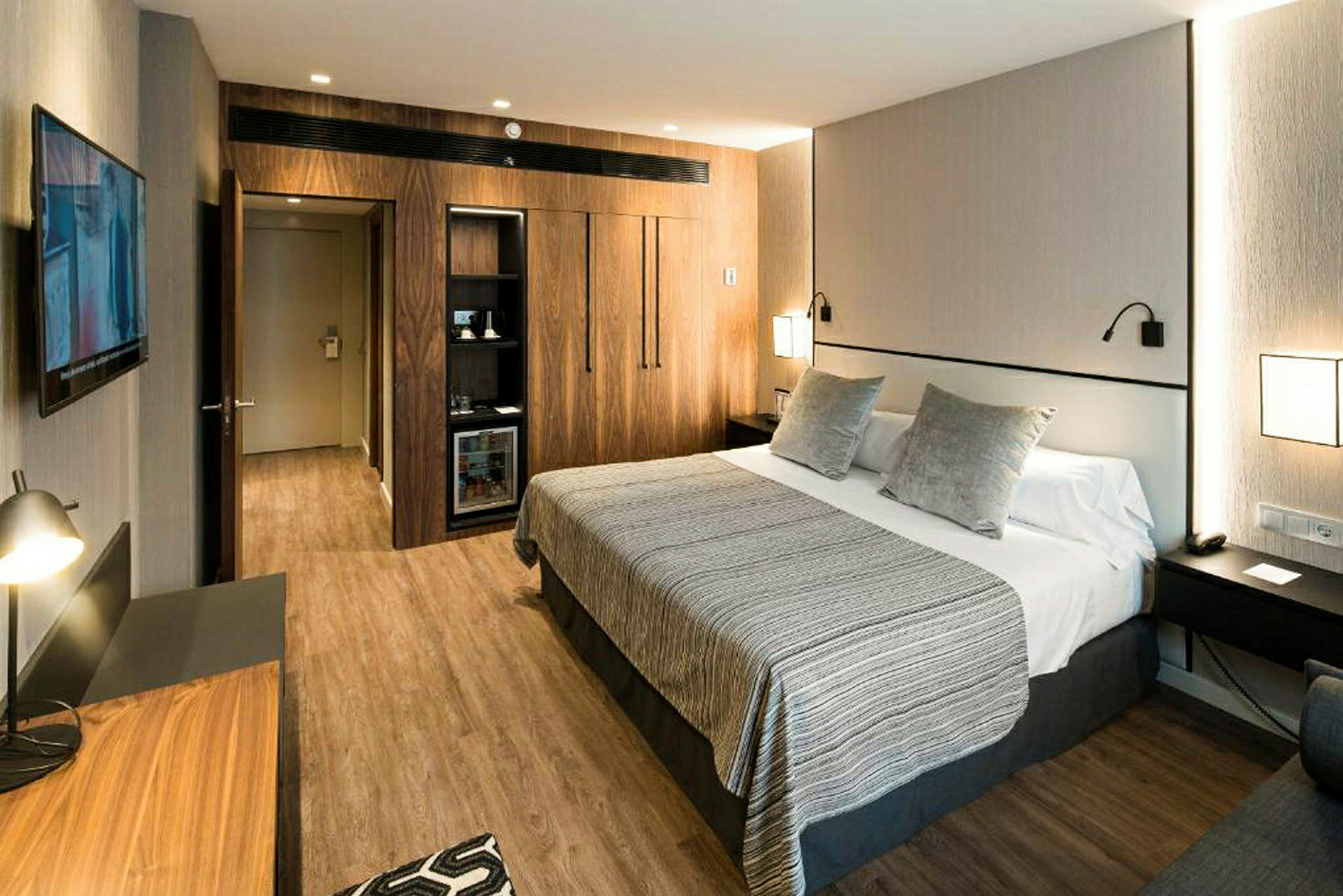 Hotellrom med stor seng, moderne innredning og tredetaljer. (AI-generert tekst)