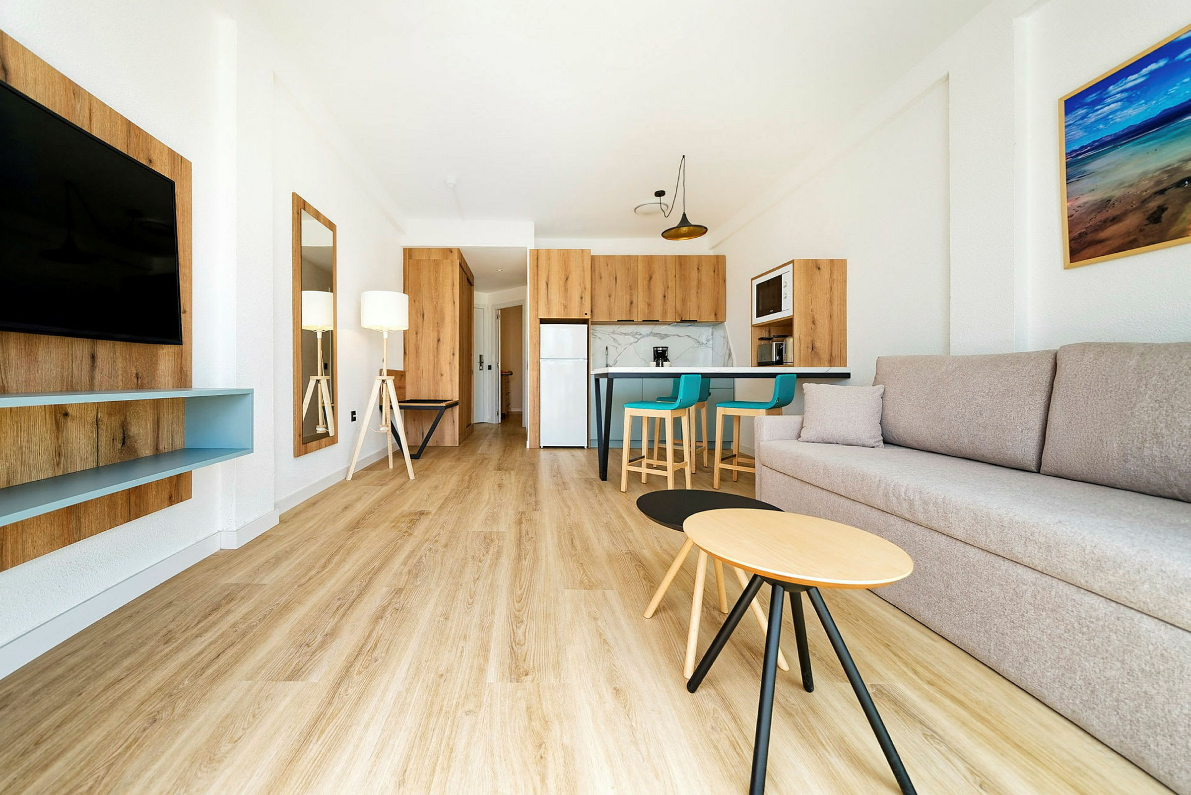 Moderne innredet stue med sofa, TV, kjøkken og spiseplass. (AI-generert tekst)