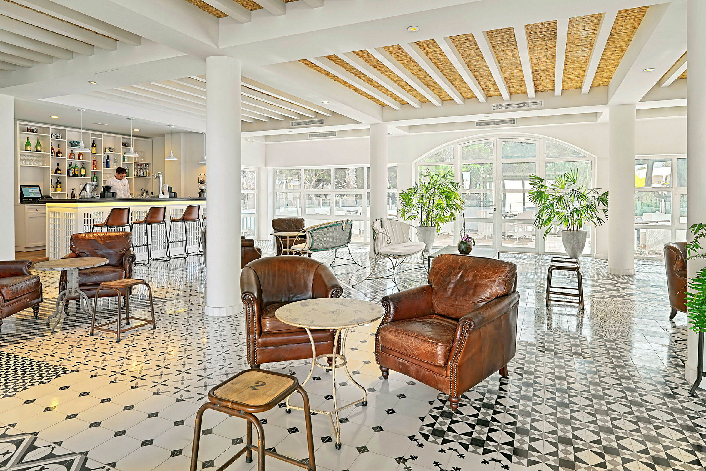 Et elegant innredet loungeområde med skinnstoler og en kafé i bakgrunnen. (AI-generert tekst)