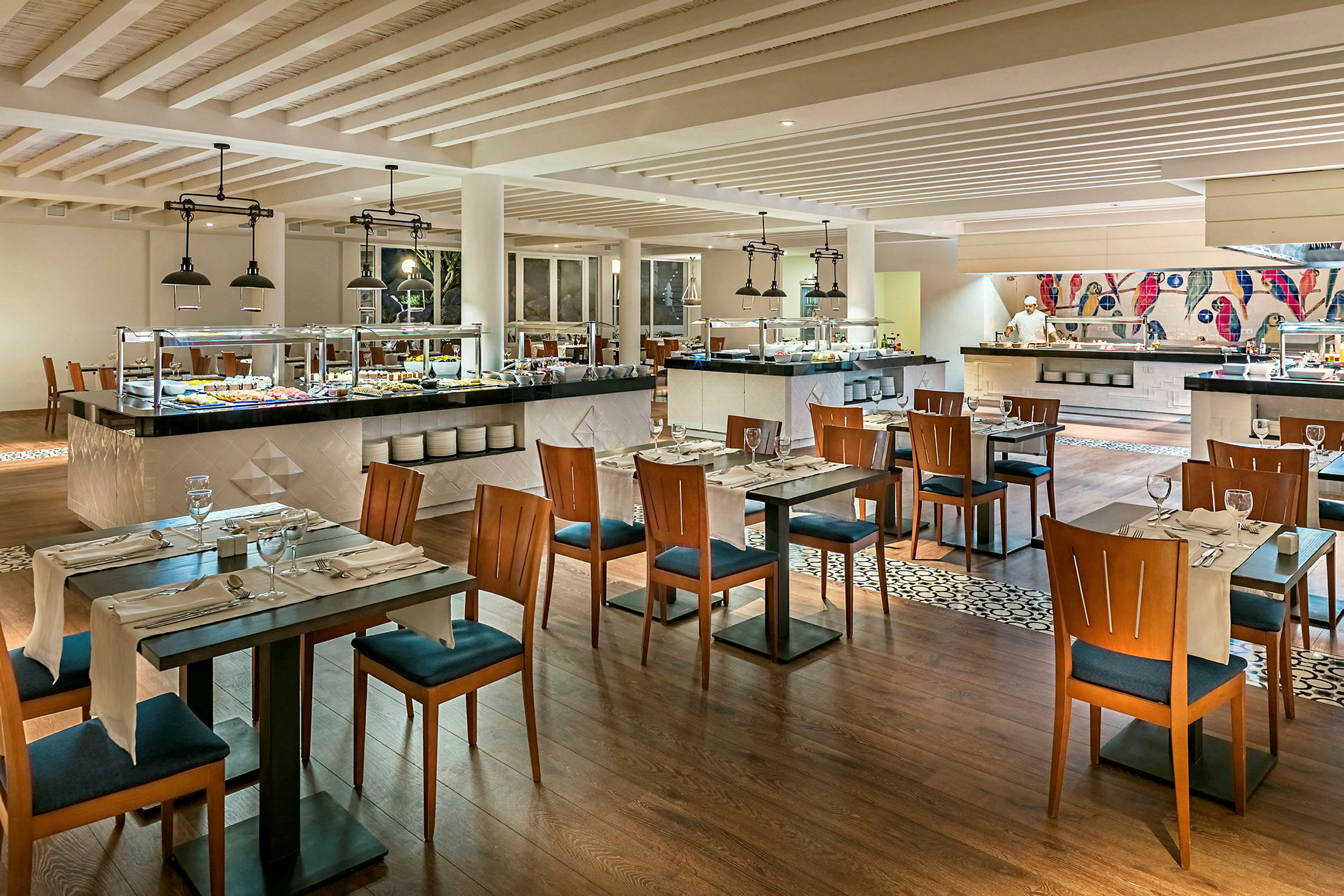En moderne restaurant med spisebord og stoler, buffetbenker med forskjellige retter og dekorasjoner. (AI-generert tekst)