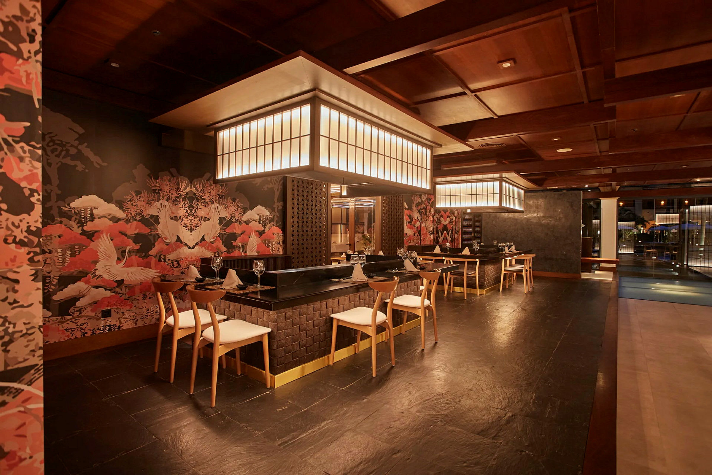 En interiør fra en elegant restaurant med moderne møbler, stilfull belysning og vegger dekorert med orientalskinspirert kunst. (AI-generert tekst)