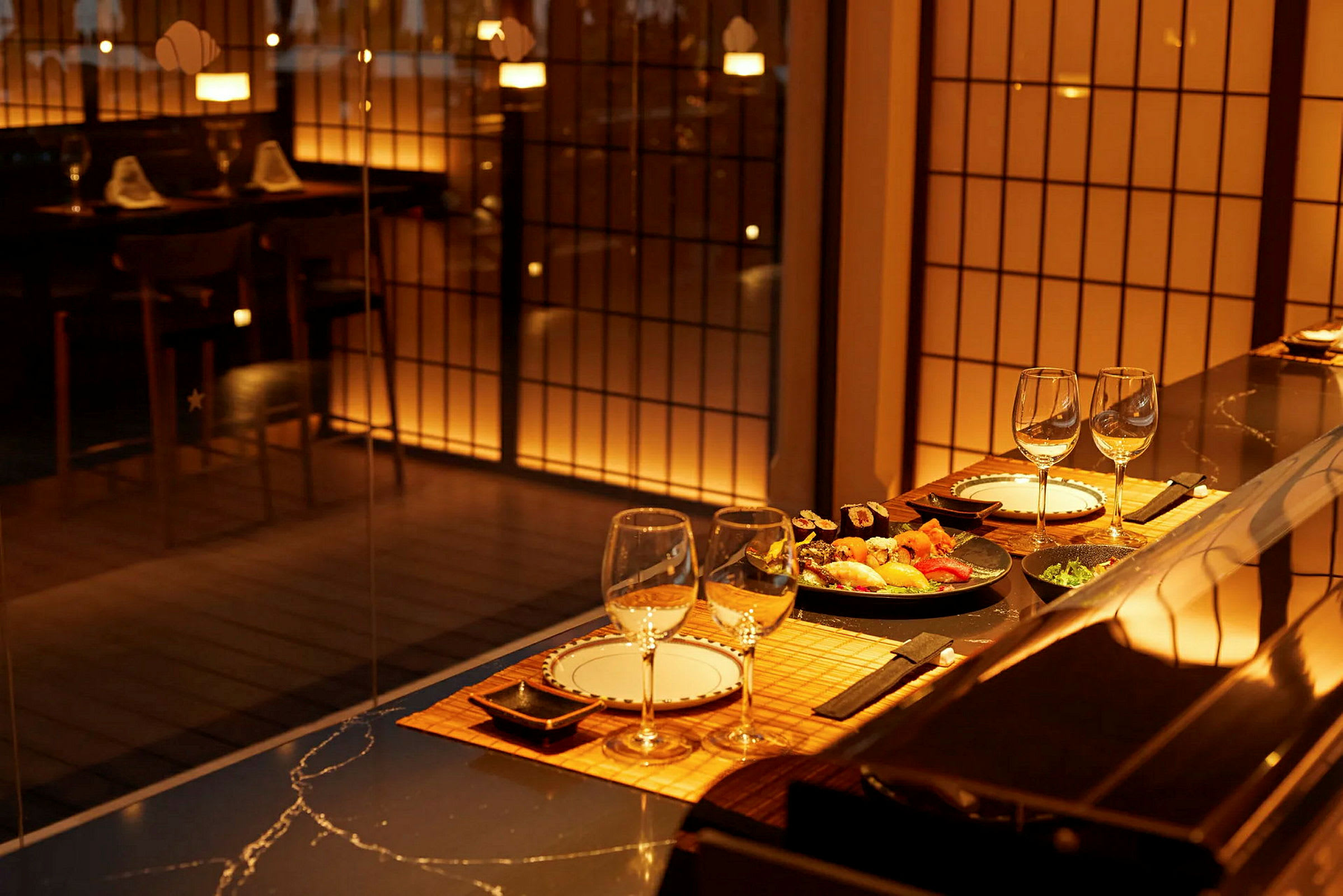 En elegant restaurant med dekket bord og sushi servert, belyst med varmt lys. (AI-generert tekst)