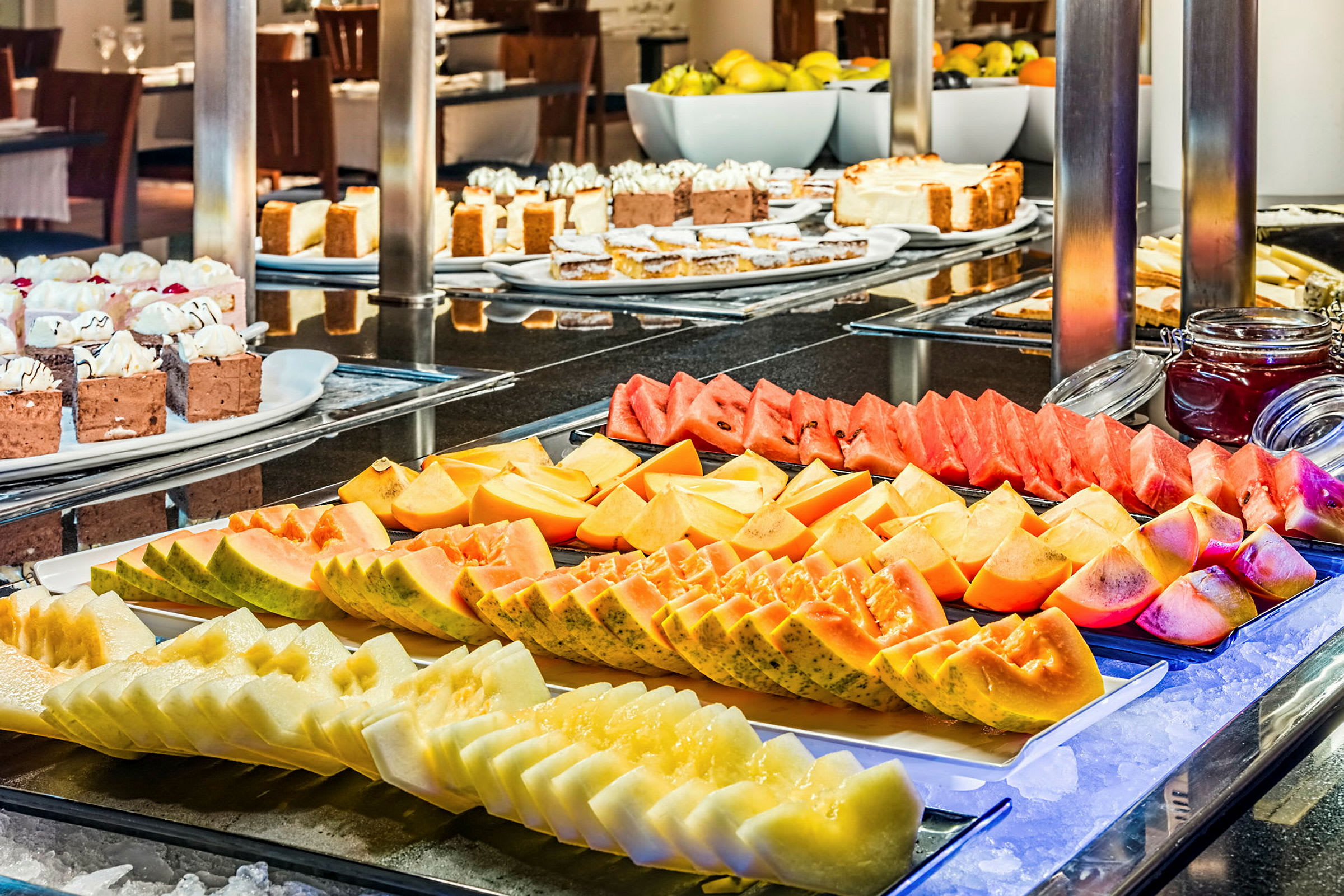 Buffet med frisk frukt og desserter på et serveringsbord. (AI-generert tekst)