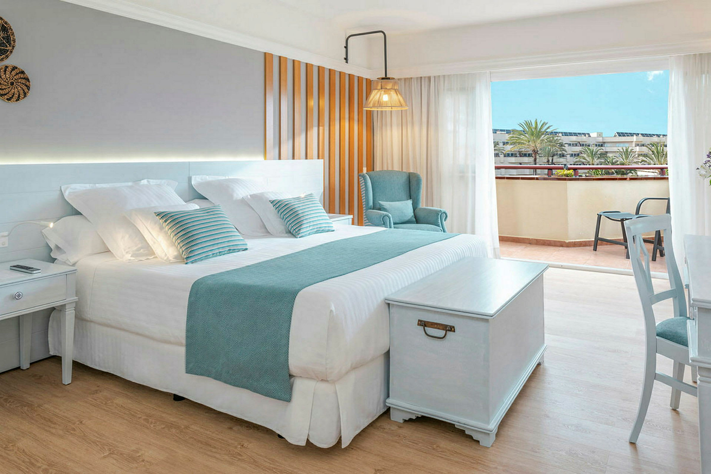 Et lyst og elegant hotellrom med en stor seng, sitteplasser og tilgang til en balkong. (AI-generert tekst)