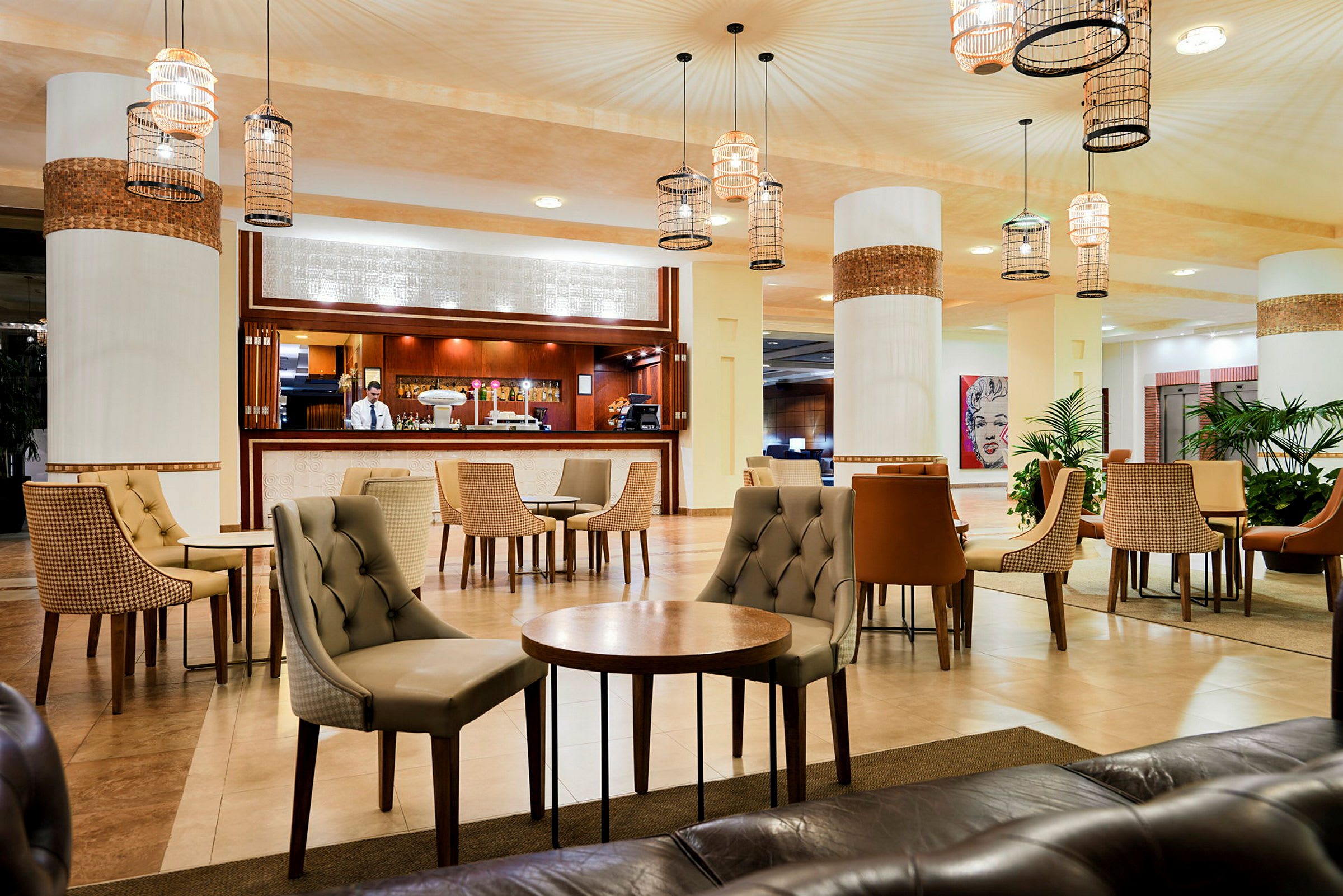 Elegant hotellobby med møblerte sittegrupper og en bemannet resepsjonsdisk. (AI-generert tekst)