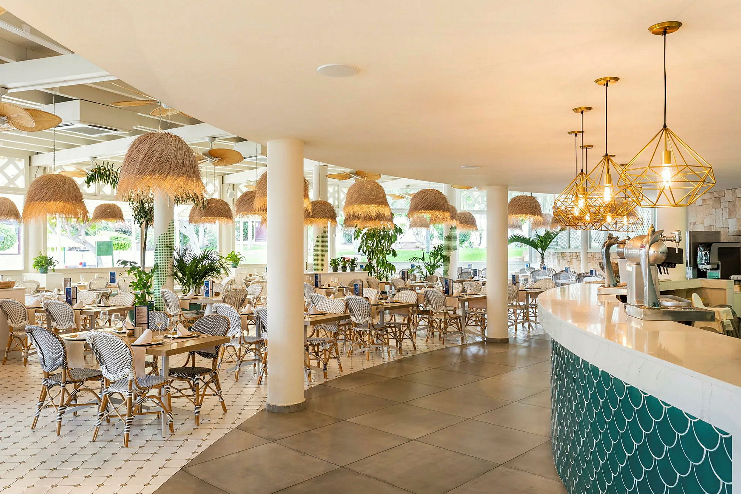 Bilde av en lys og moderne restaurant med hvite stoler og bord, hengelamper i naturnær stil, og en bar med myke linjer. (AI-generert tekst)