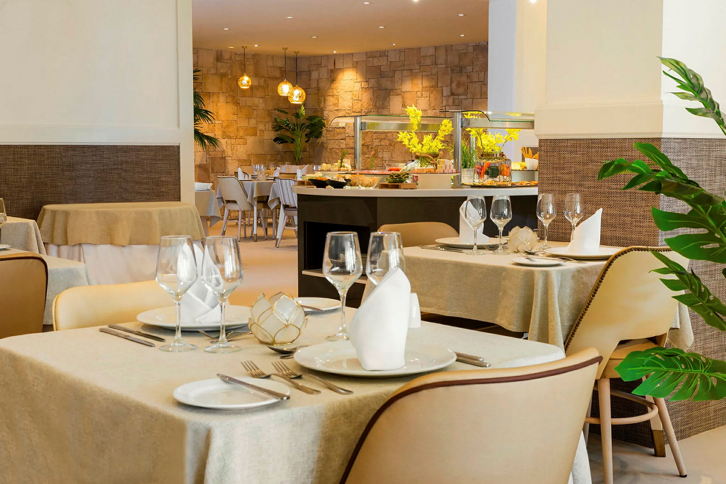 Interiør av en elegant restaurant med oppdekkede bord og dekorert buffédisk i bakgrunnen. (AI-generert tekst)