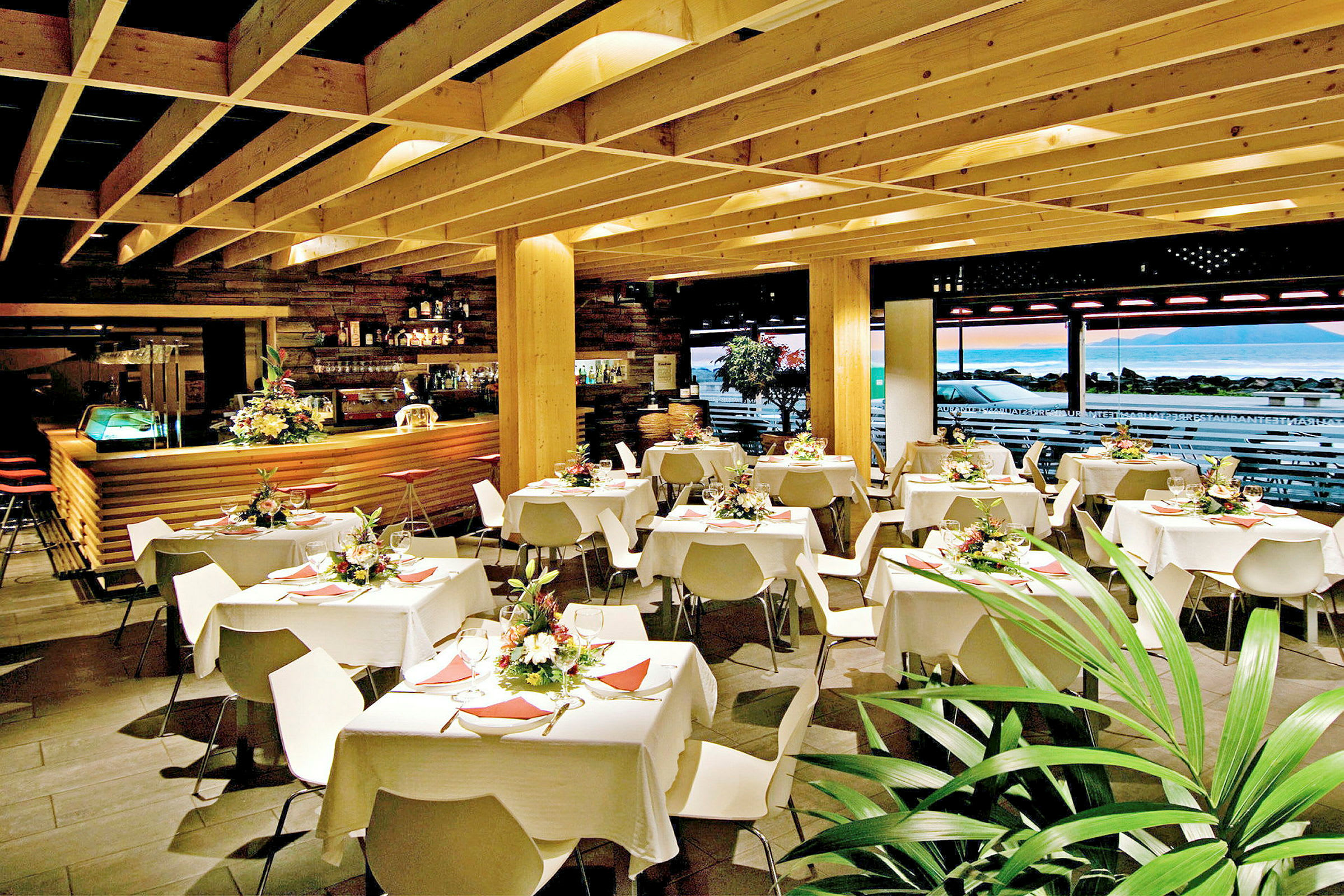 Restaurantinteriør med dekkede bord og dekorative blomster. (AI-generert tekst)