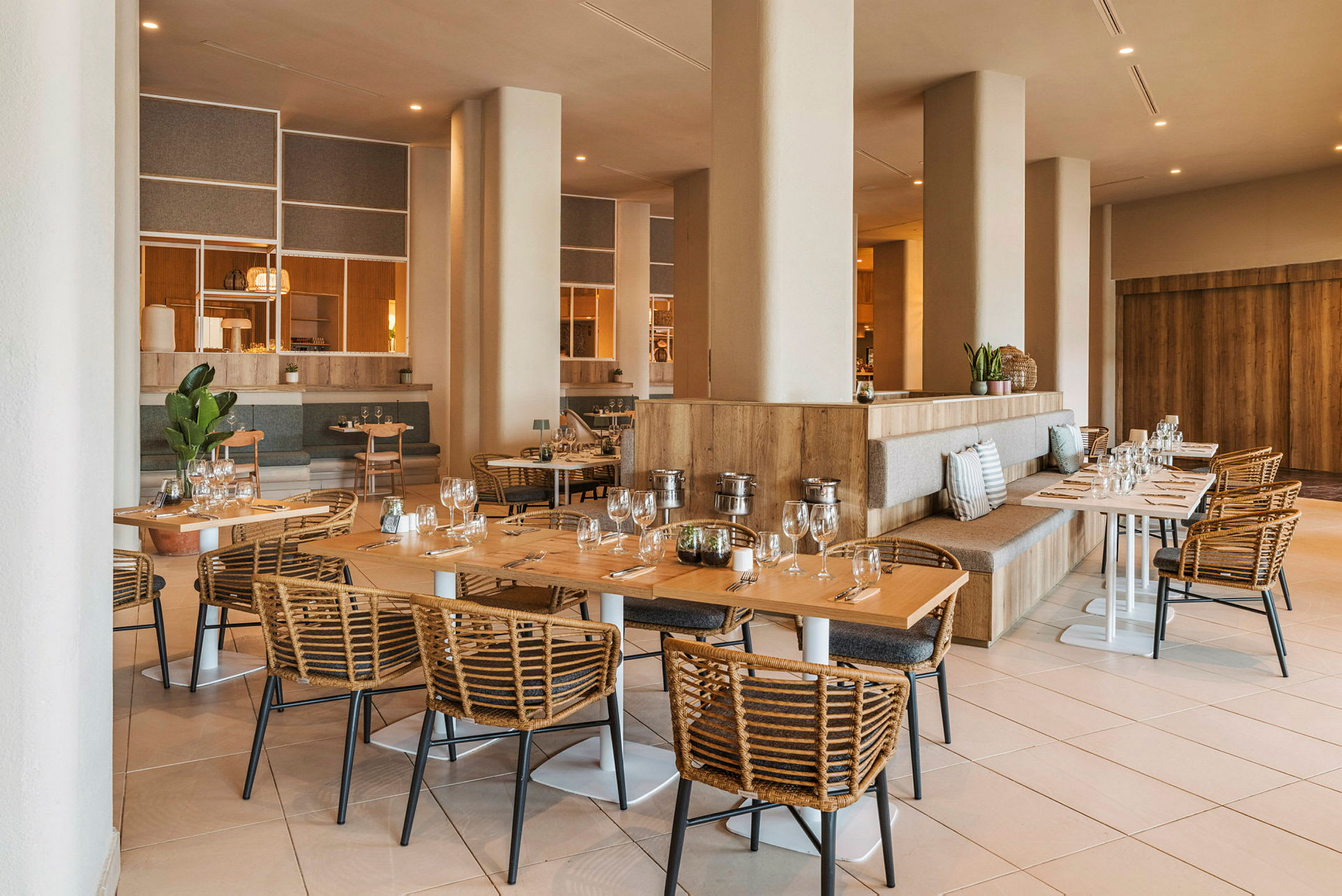 En romslig og elegant innredet restaurant med trebord og flettede stoler. (AI-generert tekst)