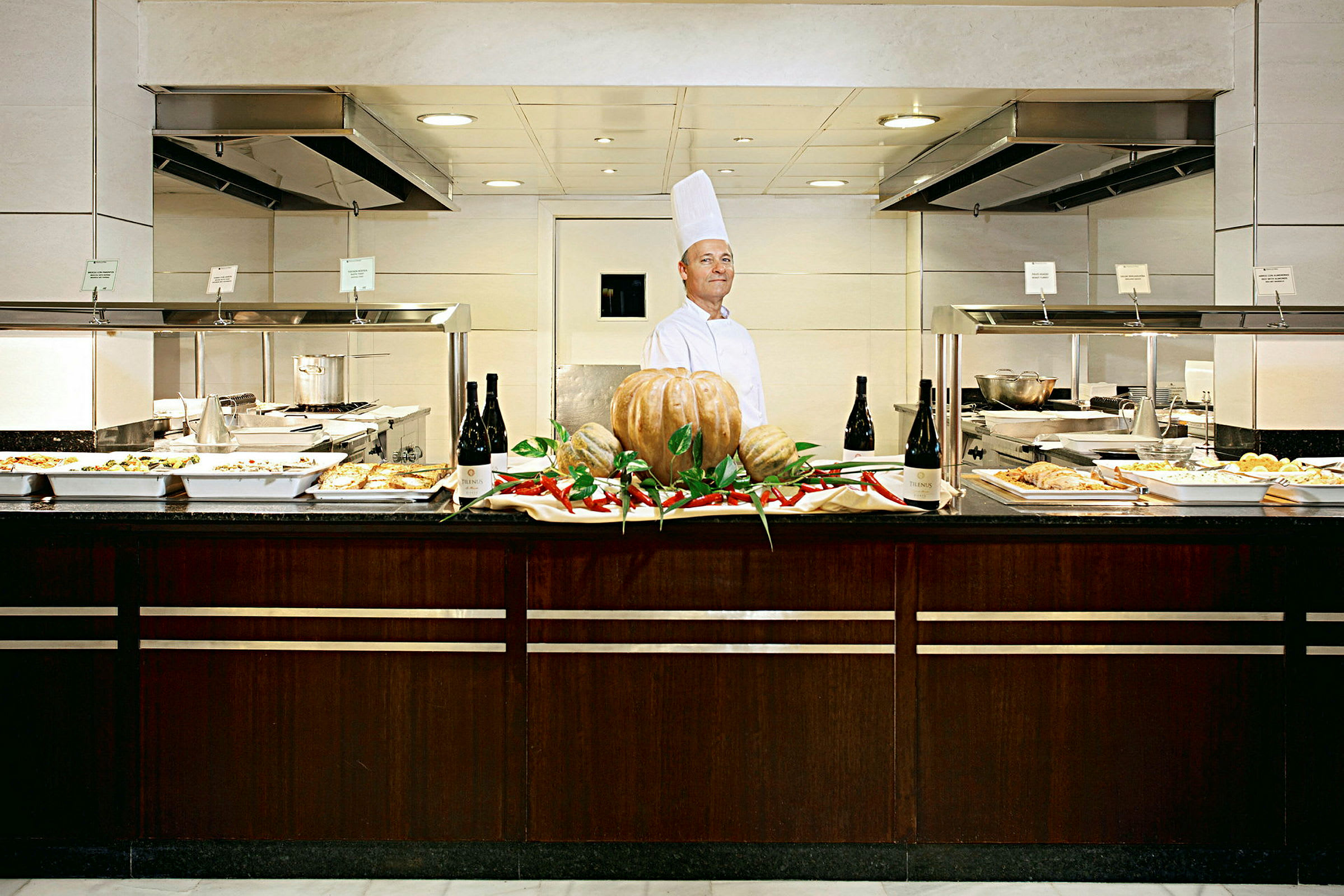 En buffet med ulike retter som passer til lunsj eller middag, med en dekorasjon av gresskar og chili i midten. (AI-generert tekst)