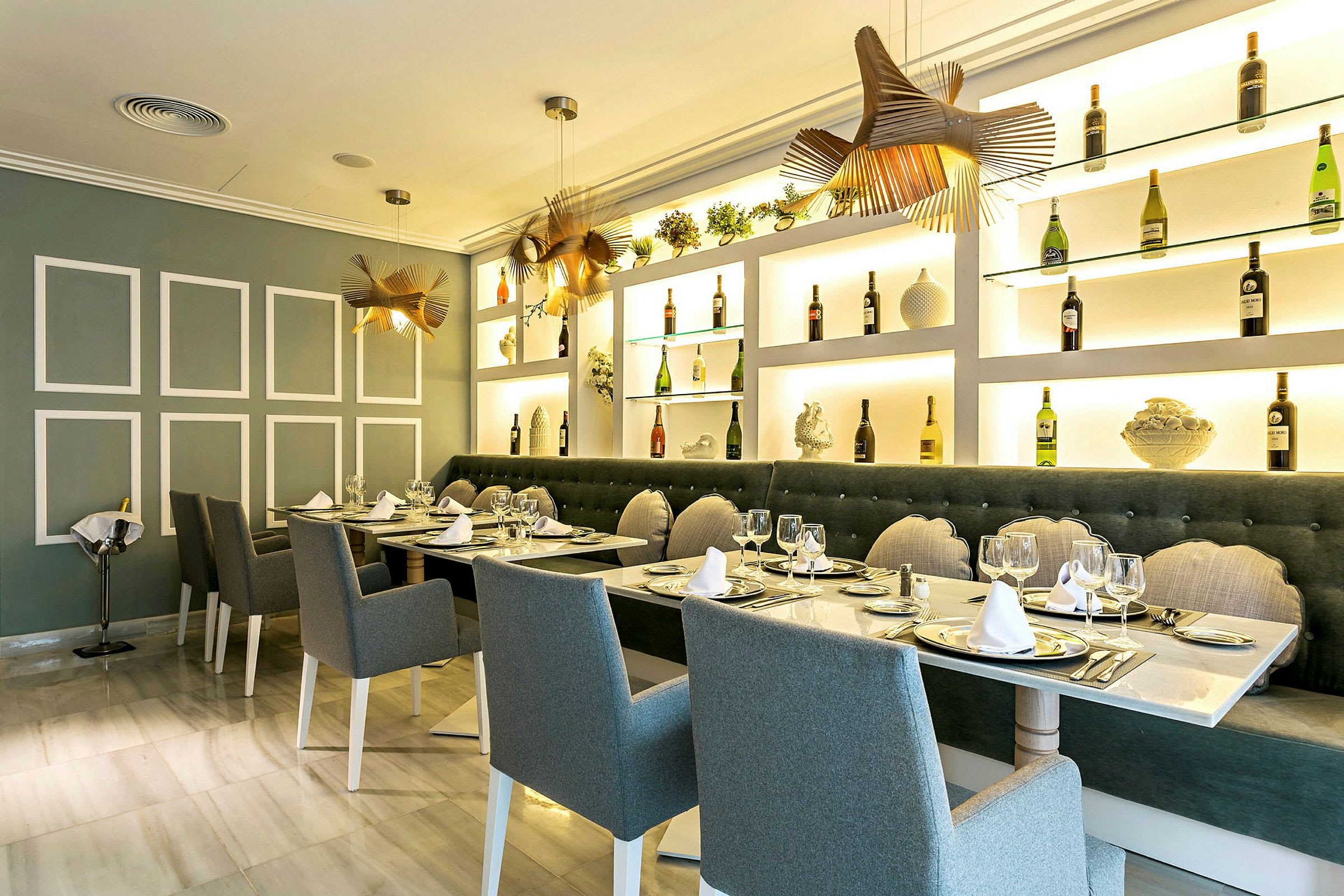 En elegant restaurant med dekkede bord, stoler og bakgrunn av hyller med flasker og dekorasjoner. (AI-generert tekst)