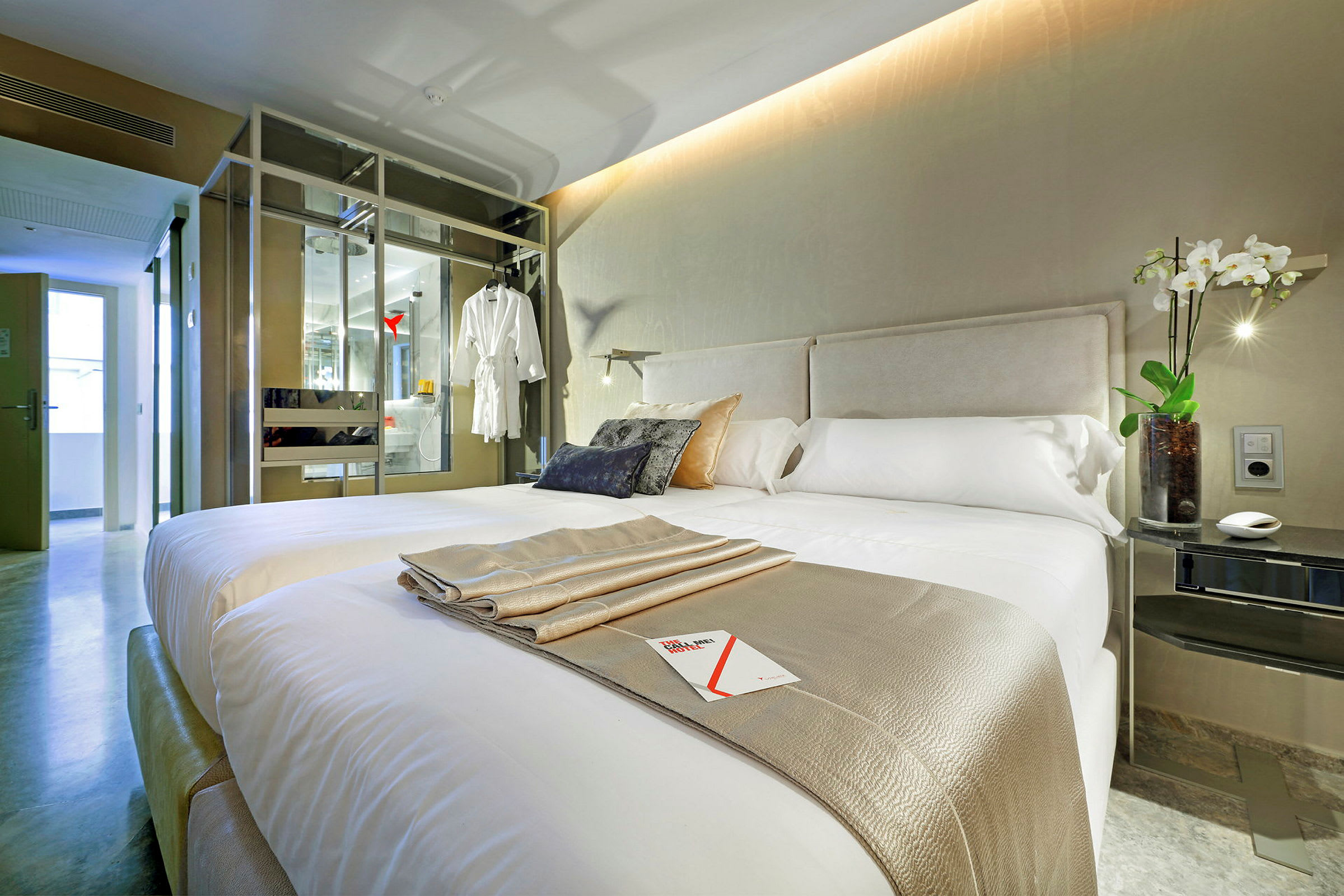Bilde av et moderne hotellrom med en dobbeltseng, dekorative puter og en elegant innredning. (AI-generert tekst)