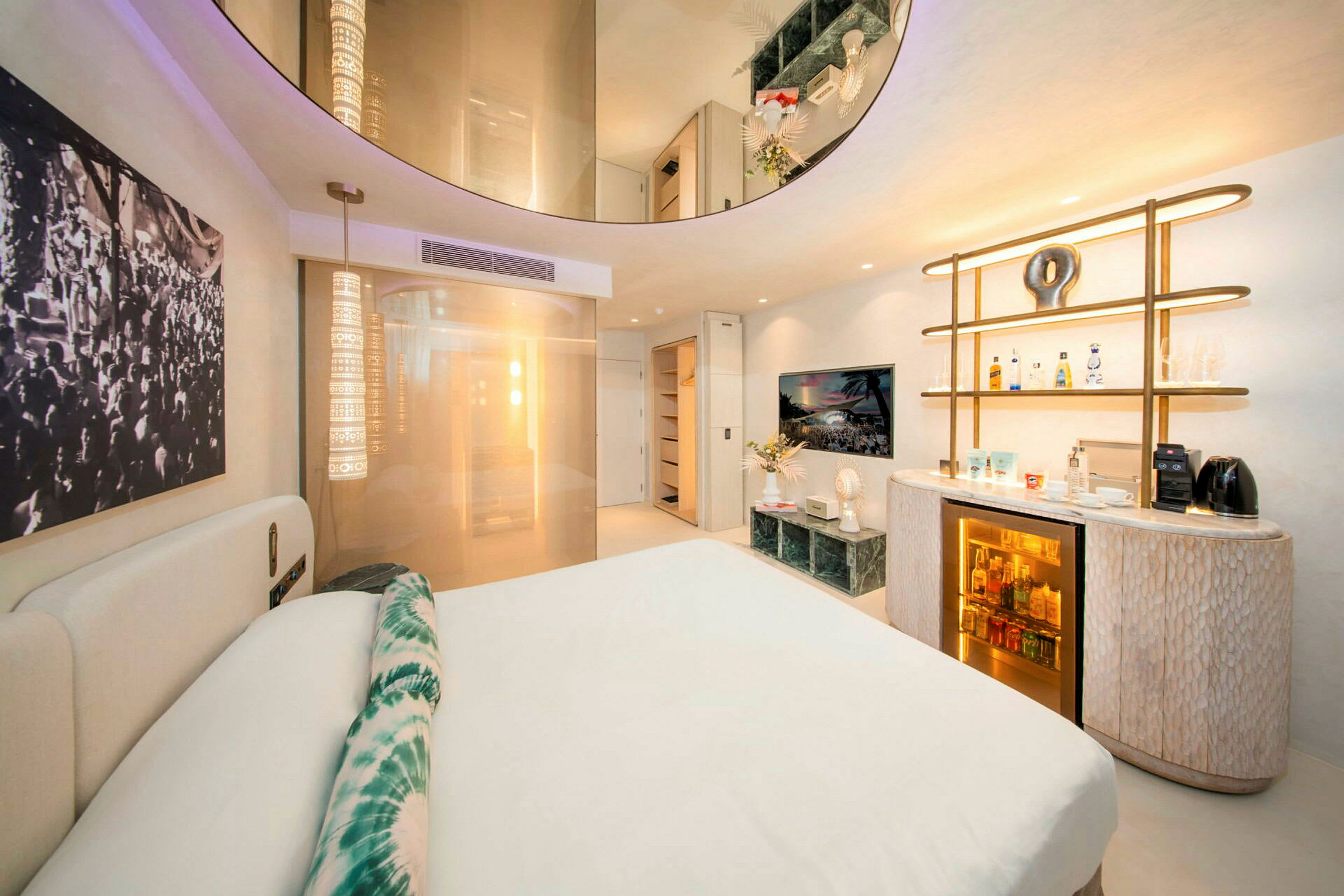 Et moderne hotellrom med en dobbeltseng, dekorativ belysning og et minibarområde. (AI-generert tekst)