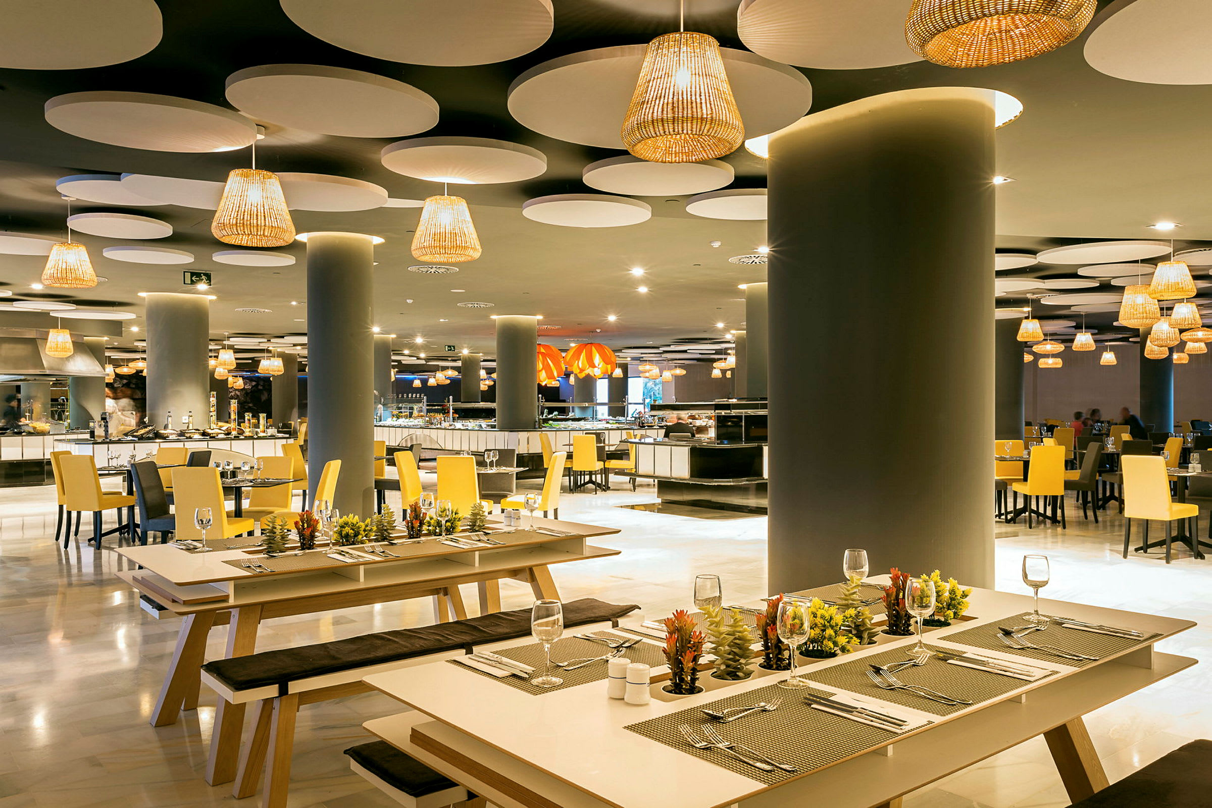 Elegant restaurant med moderne innredning, med benker og bord dekorert med små planter. (AI-generert tekst)