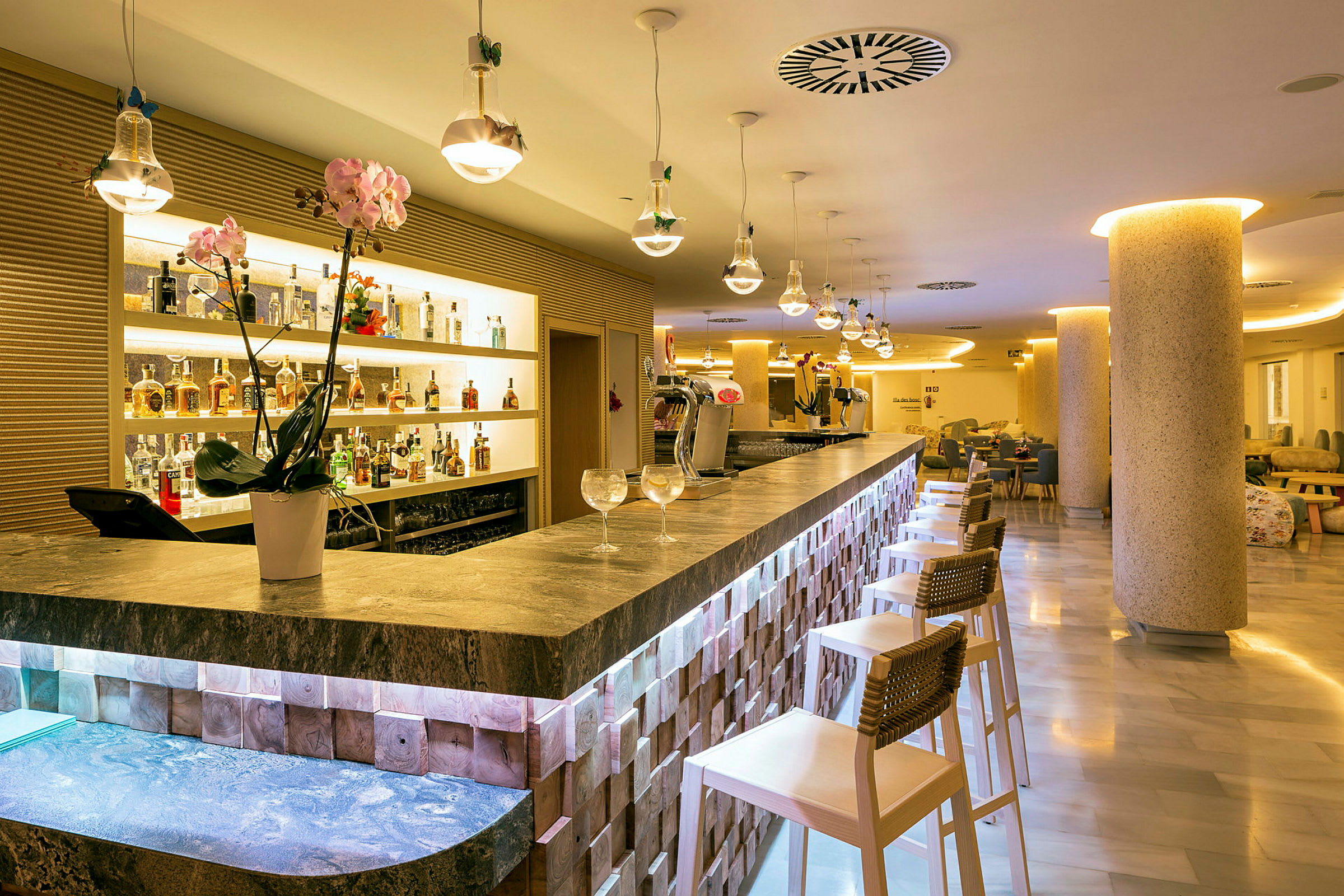 Interiør av en elegant bar med bardisk, stoler og flasker plassert på hyller. (AI-generert tekst)