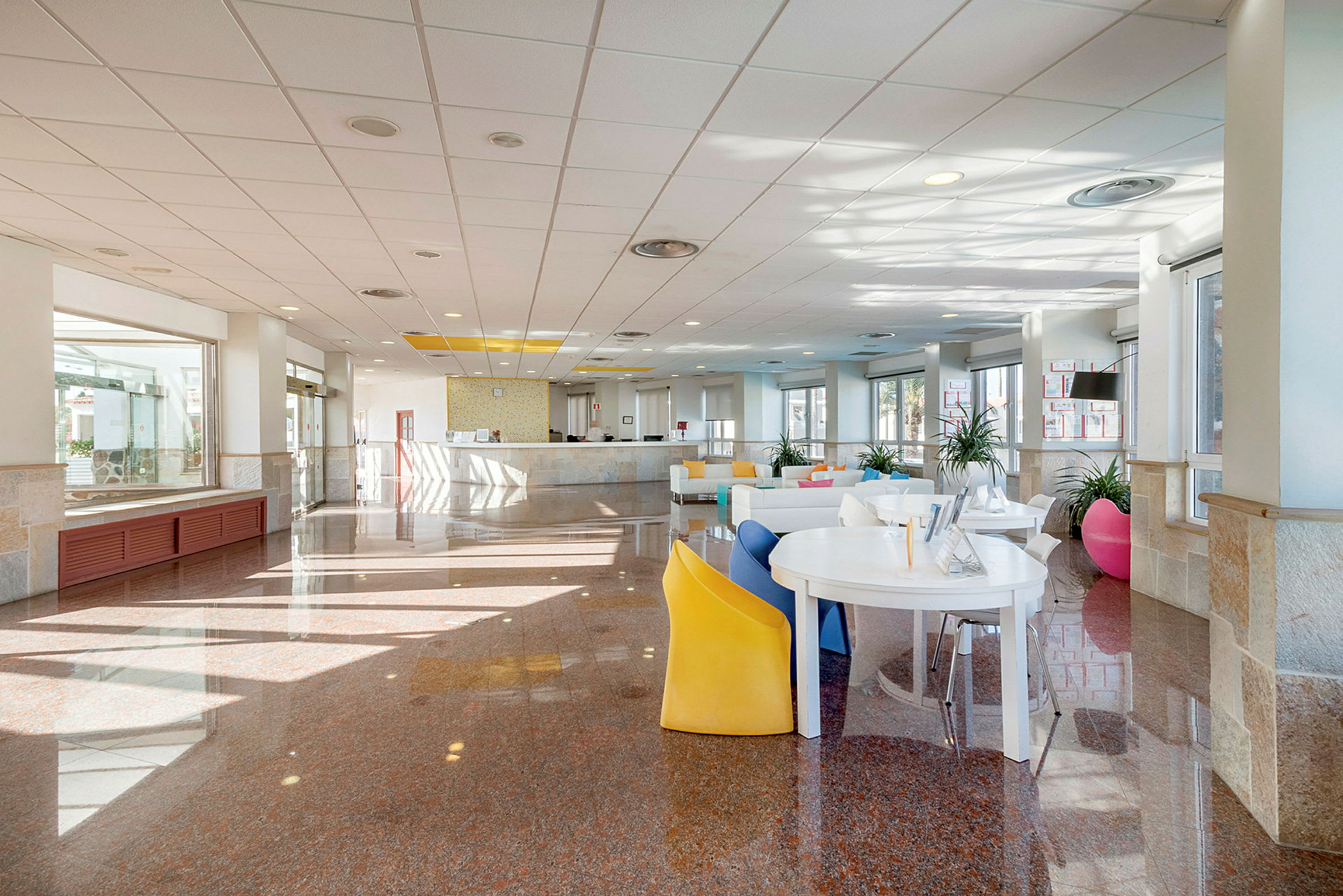Bilde av en hotellobby med en resepsjonsdisk og sitteplasser. (AI-generert tekst)