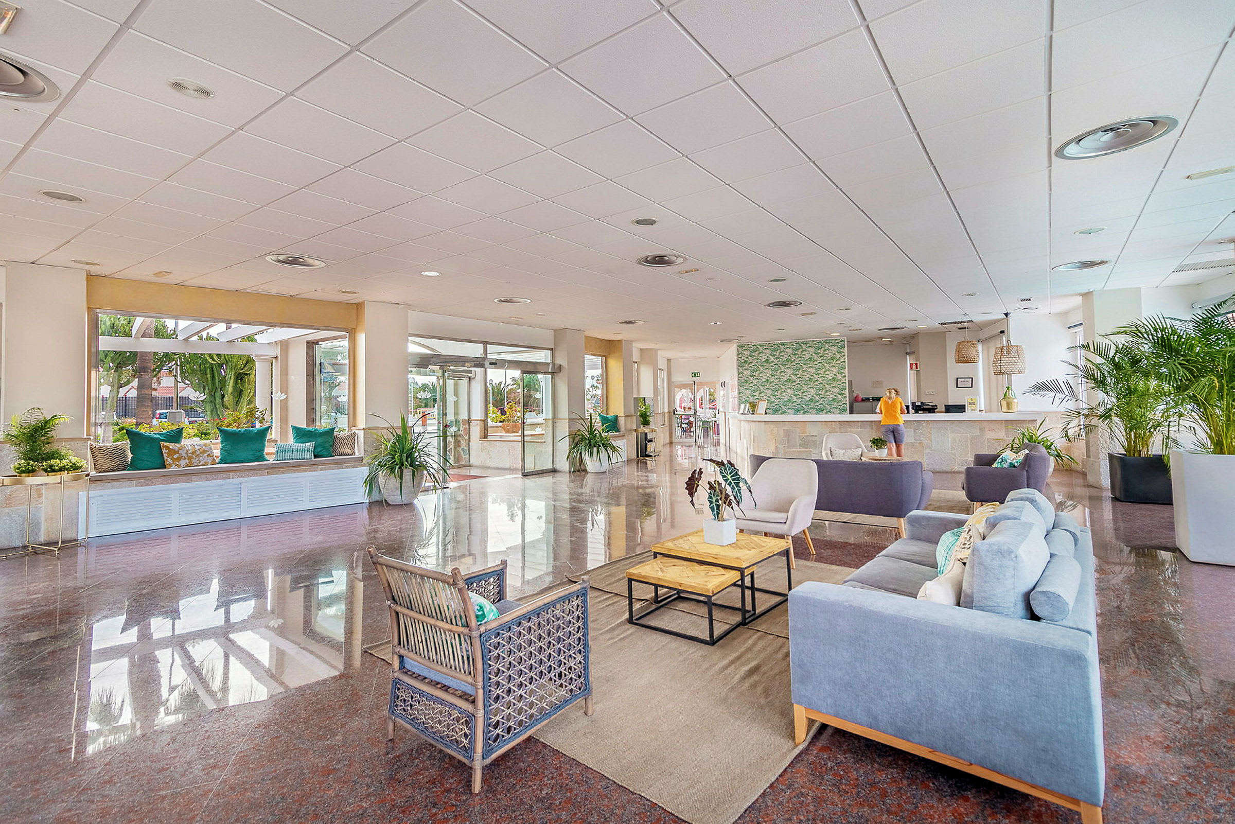 Hotellobby med sittegrupper, resepsjon og dekorative planter. (AI-generert tekst)