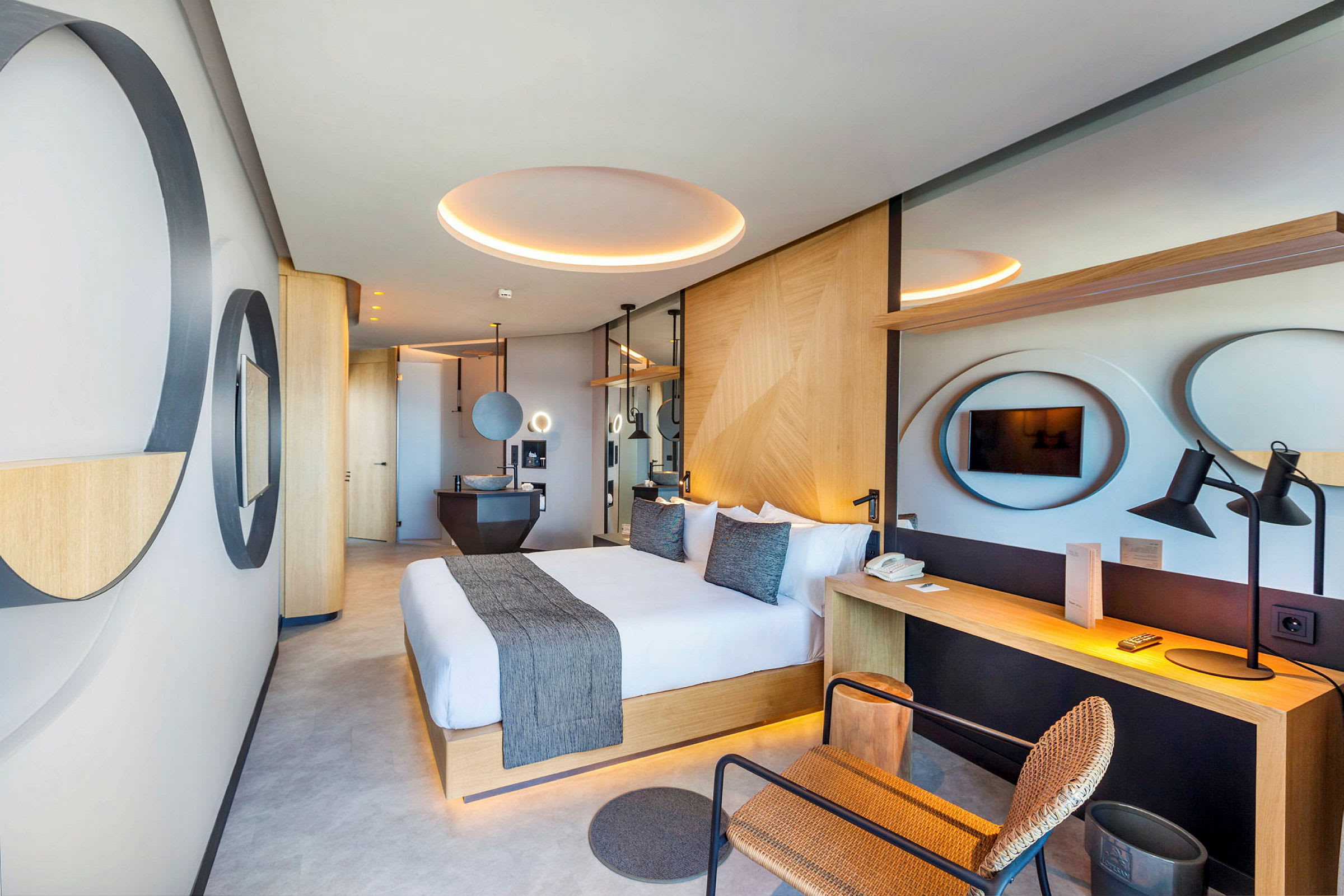Moderne hotellrom med stor dobbeltseng, skrivebord og TV. (AI-generert tekst)