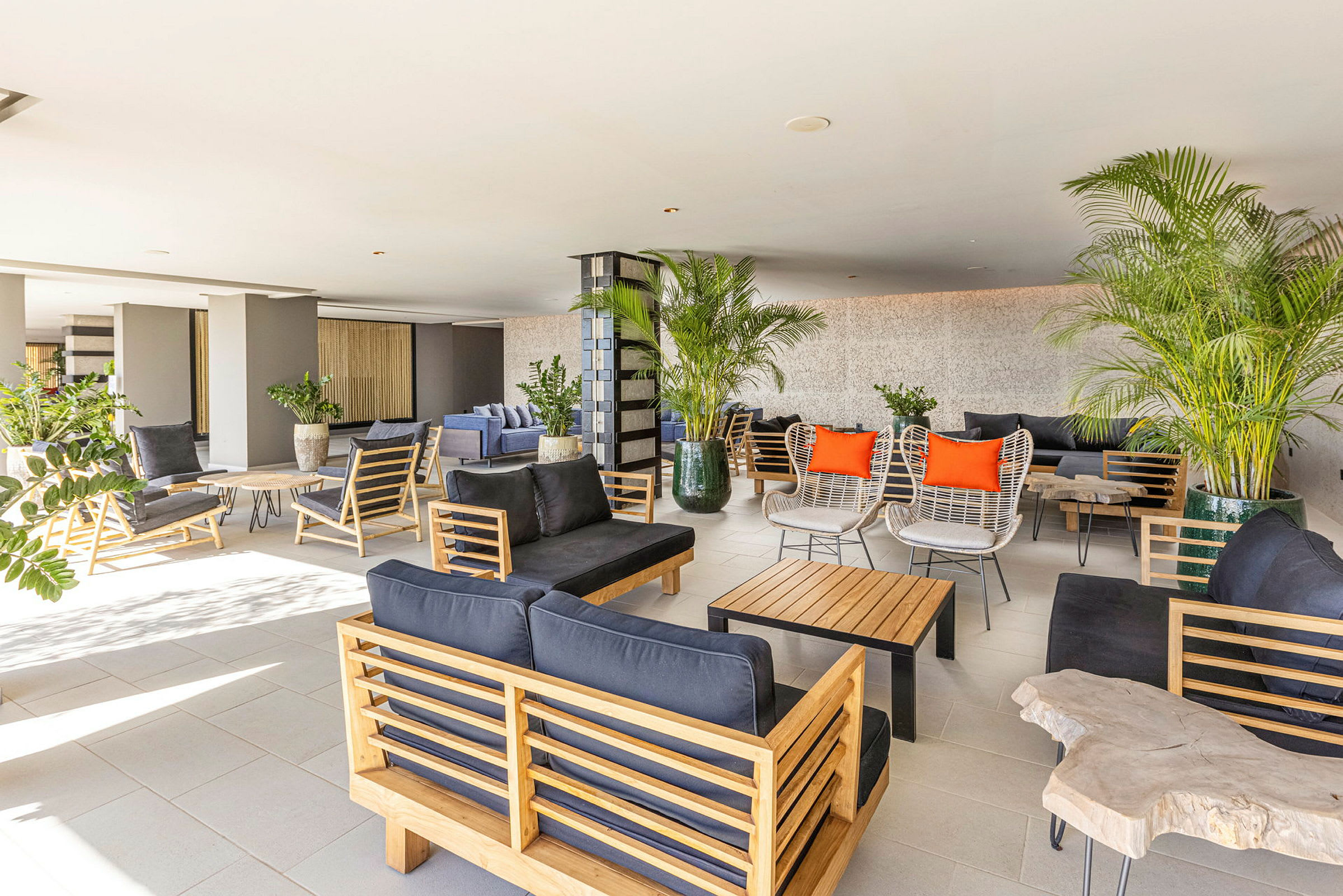 En romslig og lys lounge med moderne møbler og grønne planter. (AI-generert tekst)