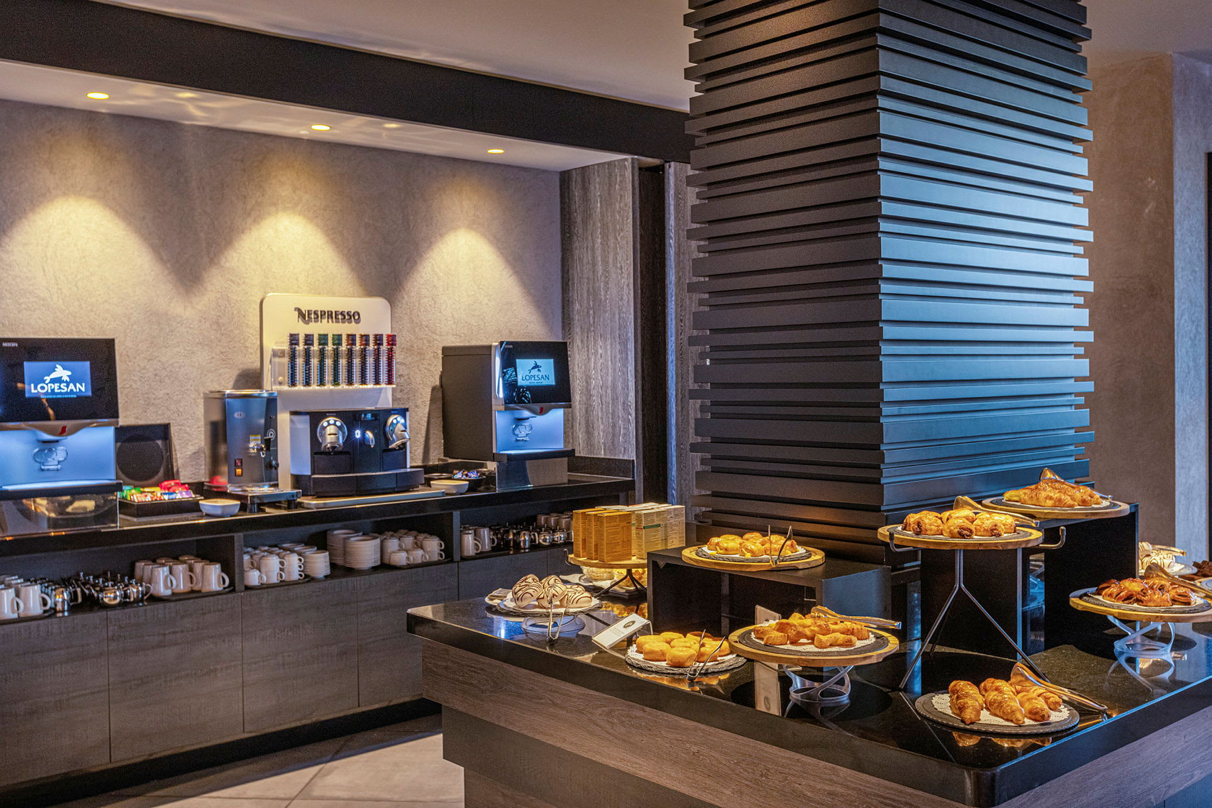 Bilde av en frokostbuffet med kaffemaskiner og et utvalg av bakverk. (AI-generert tekst)