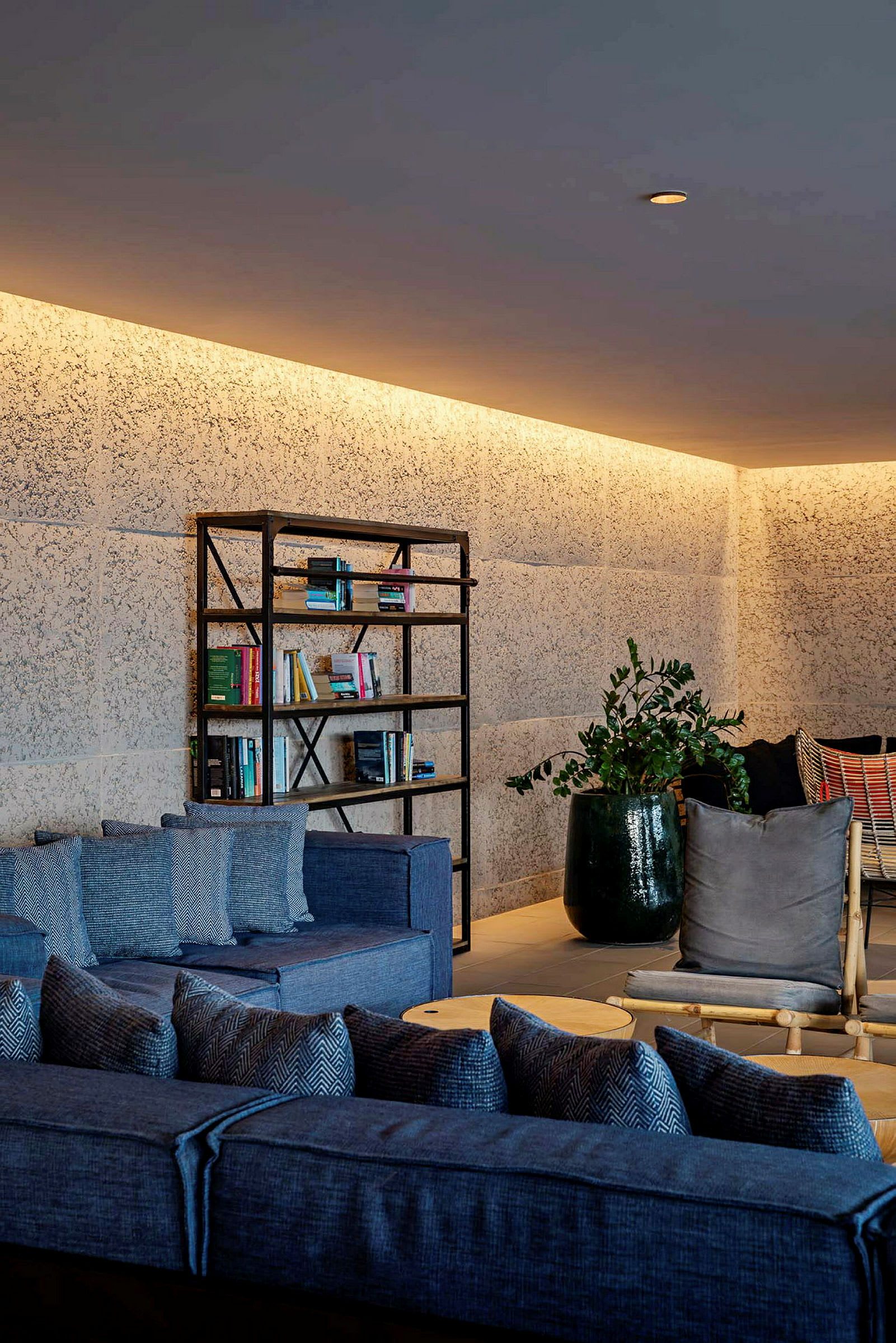 Møblert lounge med bokhylle, sofaer og planter. (AI-generert tekst)