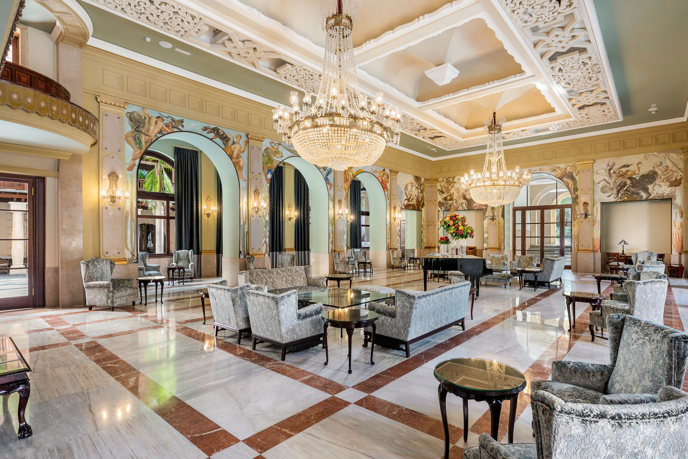 Et vakkert hotell med elegant lobby, sitteplasser og lysekroner. (AI-generert tekst)