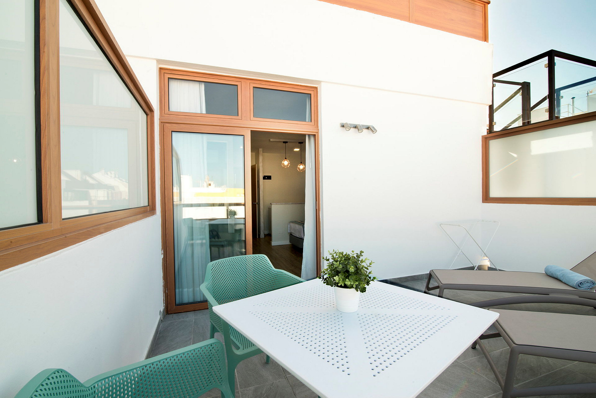 Møblert terrasse med sitteplasser, bord og solsenger. (AI-generert tekst)
