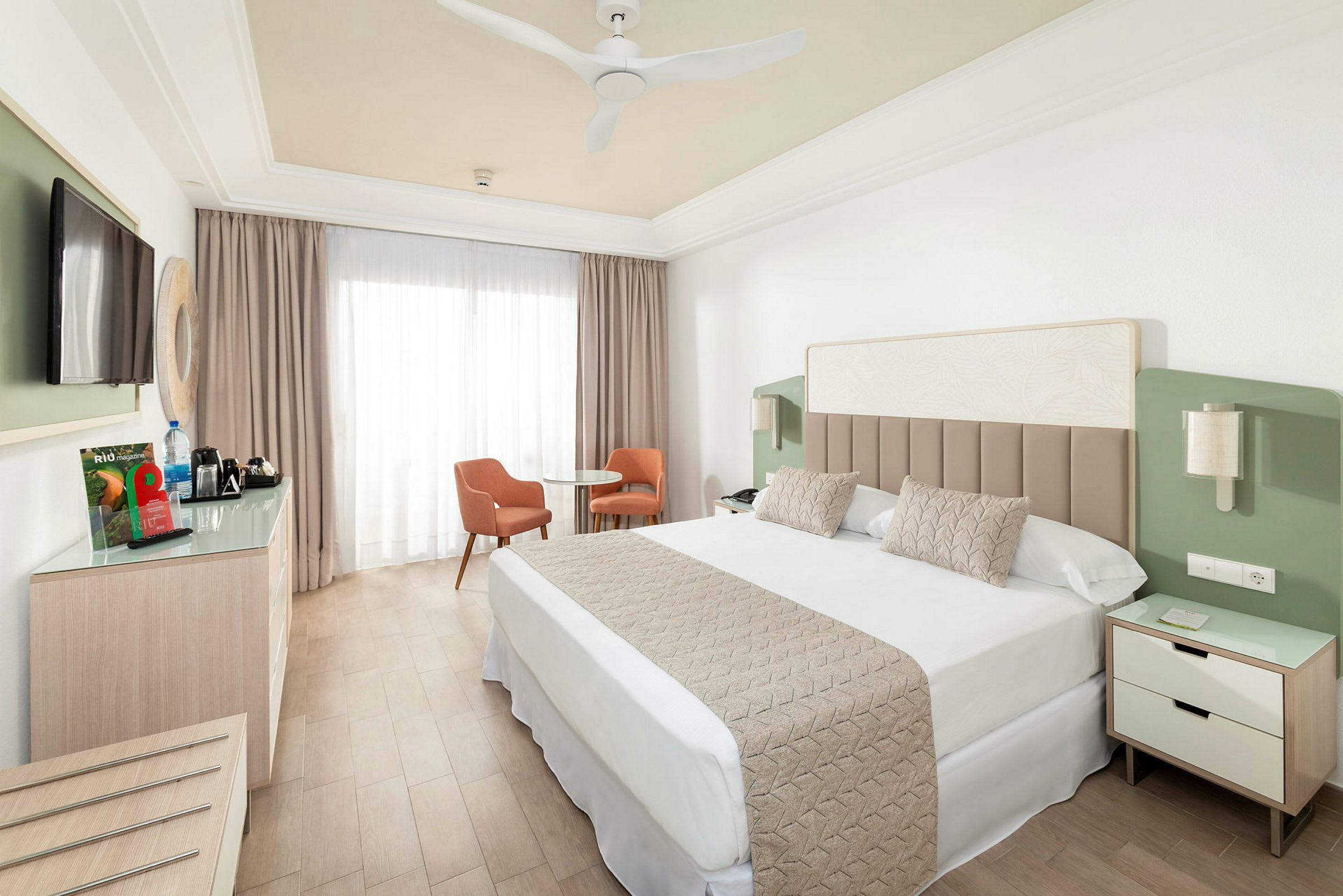 Hotellrom med dobbeltseng, TV, sittegruppe og garderobe. (AI-generert tekst)