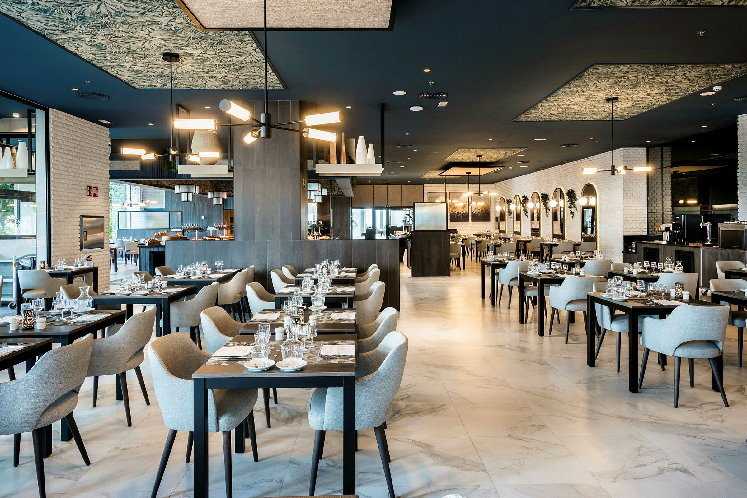 Moderne restaurant med dekkede bord og komfortable sitteplasser. (AI-generert tekst)