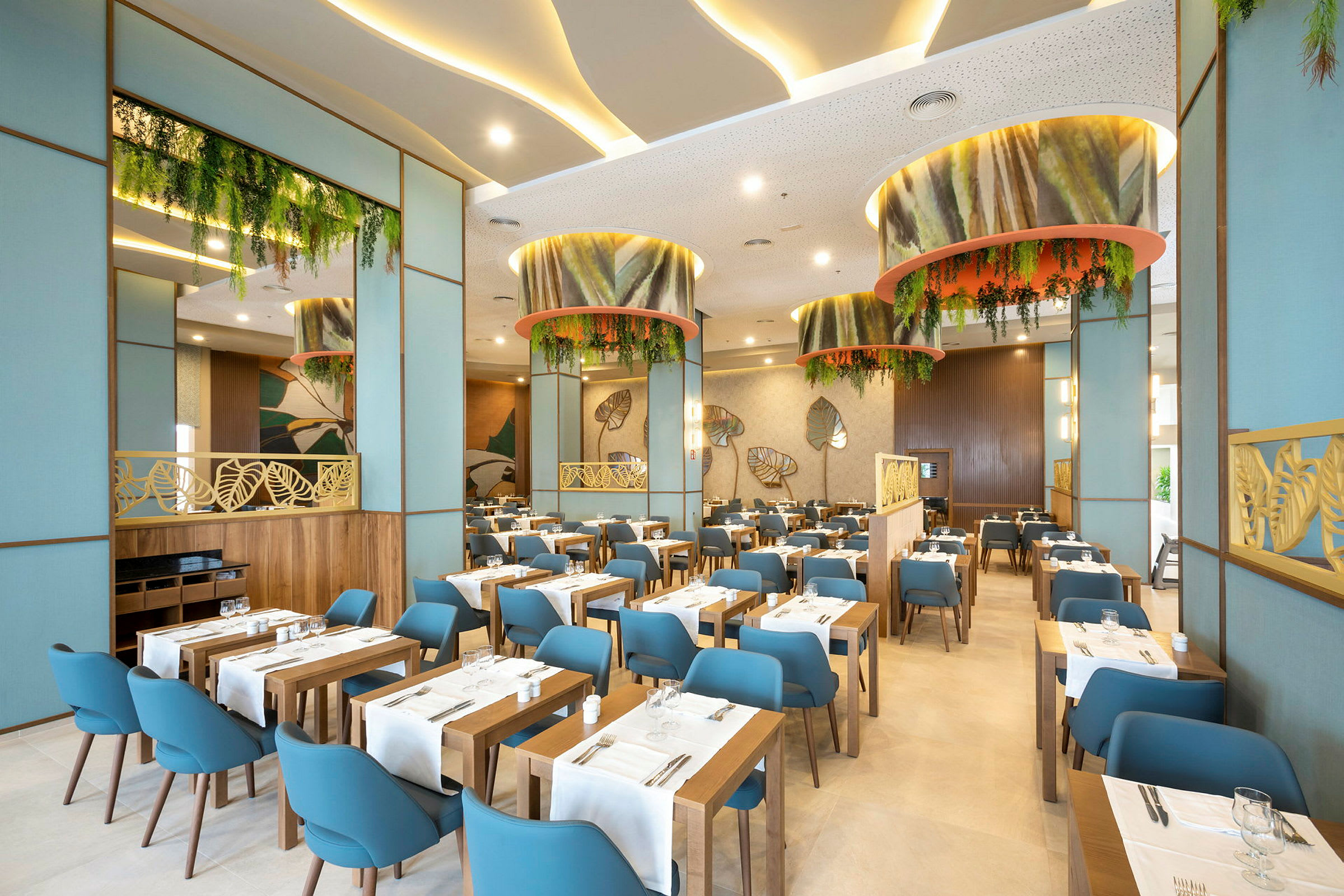 En moderne restaurantinteriør med trebord, blå stoler og grønne dekorasjoner. (AI-generert tekst)