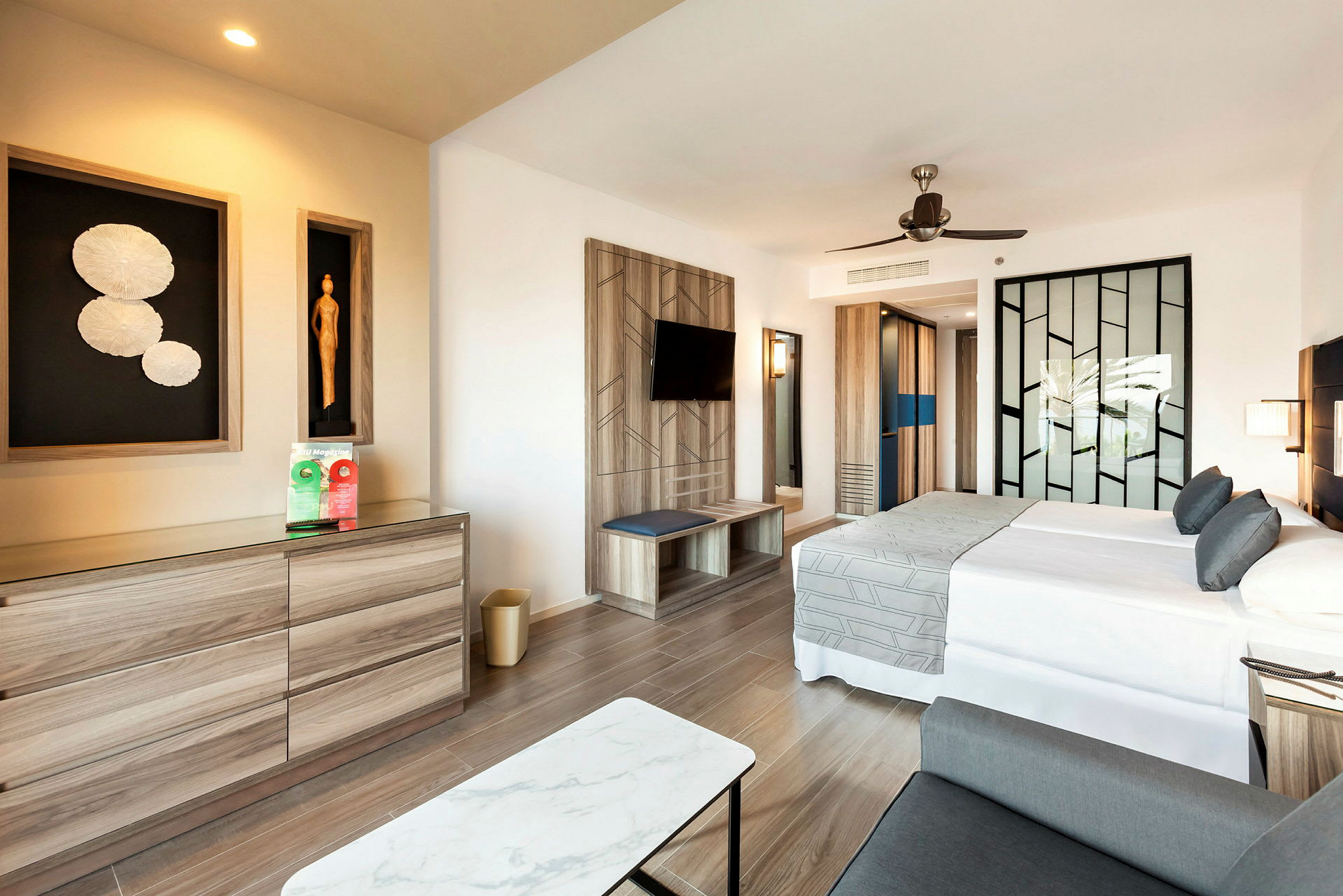 Et moderne hotellrom med en dobbeltseng, en dekorativ vegg og en kommode. (AI-generert tekst)