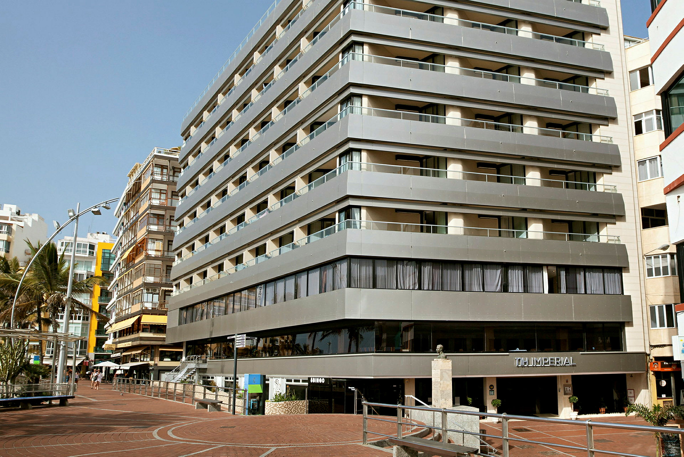 Bilde av en moderne hotellbygning med flere etasjer og balkonger. (AI-generert tekst)